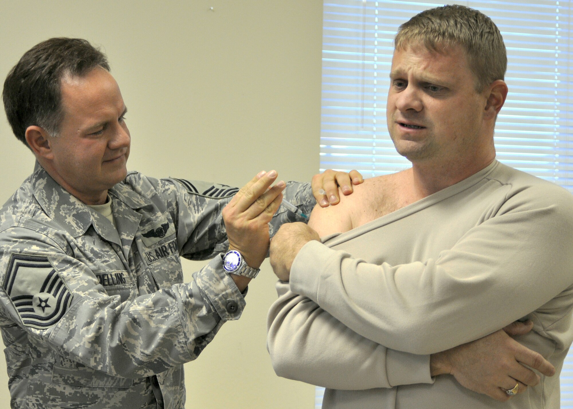 Tech. Sgt. Jason Kennedy, a fuels technician for the 917th Logistics Readiness Squadron on Barksdale Air Force Base, La., grimaces as he receives a H1N1 flu vaccination January 8, 2010 during his Unit Training Assembly (UTA) weekend. Mass vaccinations took place over the UTA weekend at the 917th Medical Squadron on Barksdale. The seasonal influenza vaccinations given every year do not protect against the pandemic H1N1 influenza. Because of this, the H1N1 vaccinations are recommended for all and mandatory for military members.  (U.S. Air Force Photo/Senior Airman Crystal Marie Jordan)