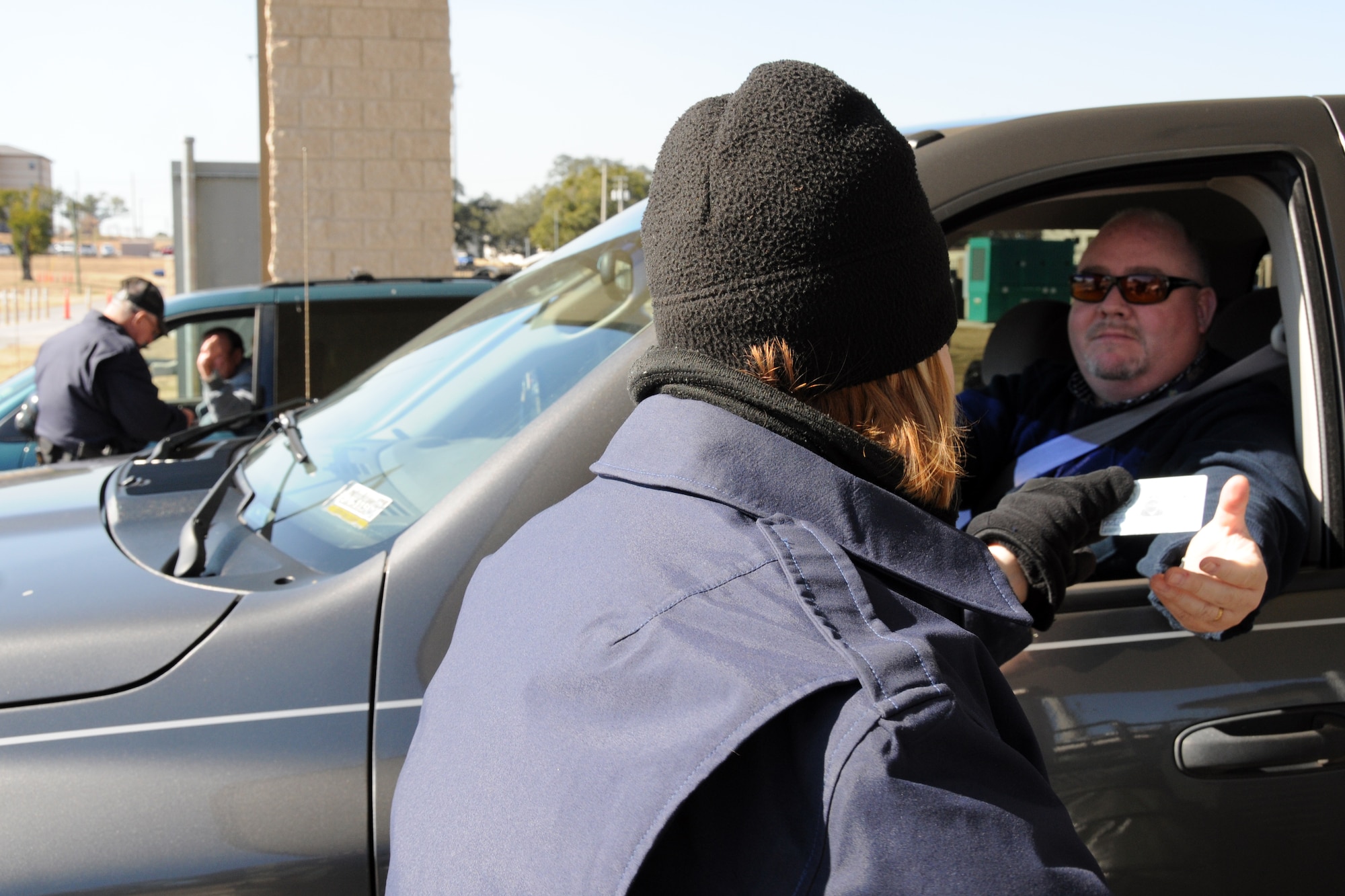EGLIN AIR FORCE BASE, Fla. -- Tracy McDaniel and Donald Osborne check IDs at the East Gate Jan. 12, here. New manpower increases have helped alleviate slow downs and congestion during peak periods throughout the day. This is just one of the initiatives base officials are taking to help traffic flow on Eglin.  (U.S. Air Force photo/ Airman 1st Class Anthony Jennings)