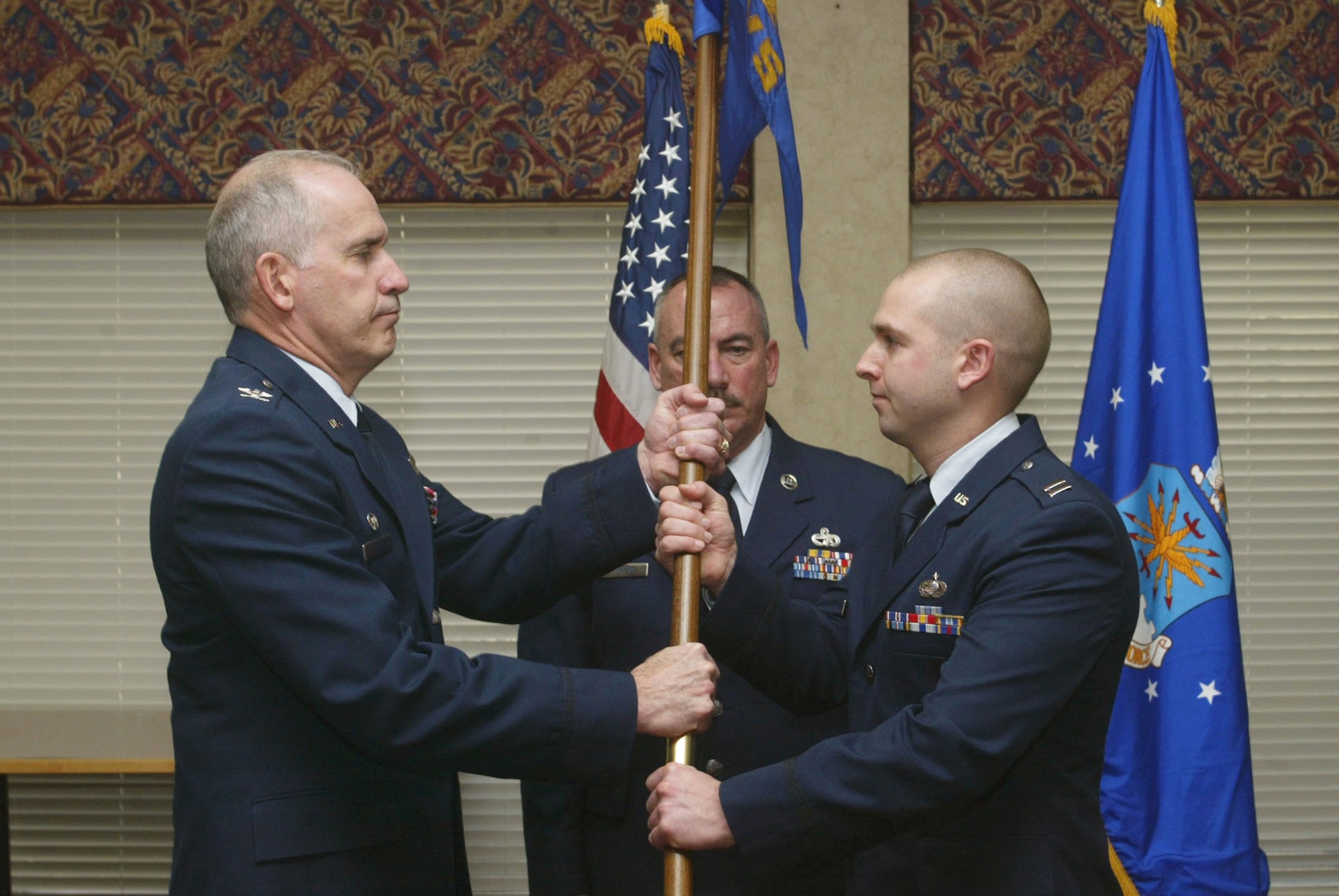 Capt. Nicholas Franz receives the unit flag from Col. Steven Slick, Commander of the 94th Mission Support Group, during an assumption of command ceremony held Jan. 9. Captain Franz was appointed as the new 94th Services Squadron Commander. (U.S. Air Force photo/Don Peek)