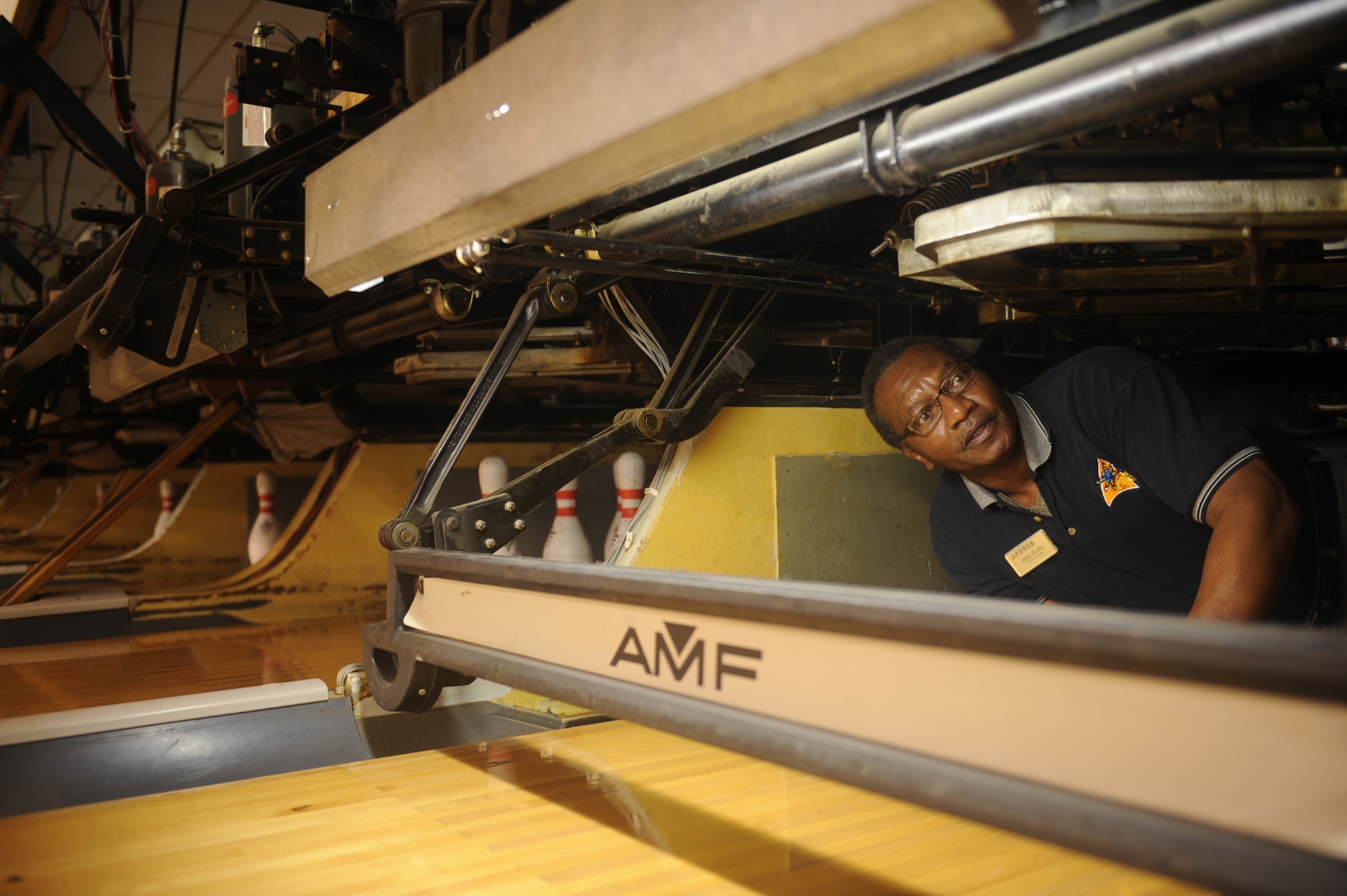 Allen Ruffin, Planet Bowl recreation supervisor, adjusts the pinspotter on Seymour Johnson Air Force Base, Jan. 7, 2010.  The pinspotter machine's function was originally performed by a person who would manually reset bowling pins in their correct position, clear fallen pins and return bowling balls to players. (U.S. Air Force photo/Senior Airman Ciara Wymbs)