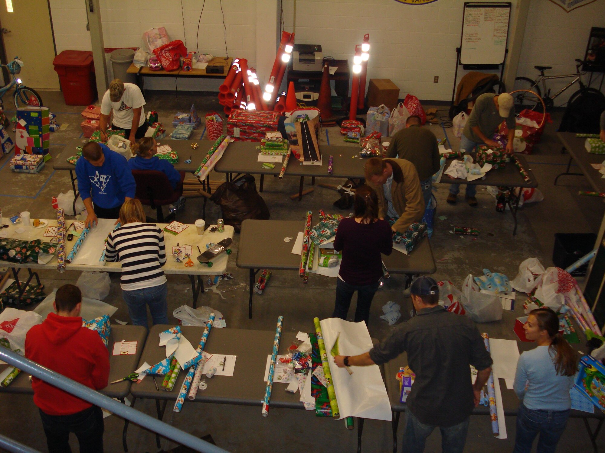 Volunteers from the Company Grade Officer Council wrap presents in the 1st Special Operations Component Maintenance Squadron’s mobility bay at Hurlburt Field. The volunteers spent six hours wrapping the presents before they were given out to children on base. (Courtesy photo)