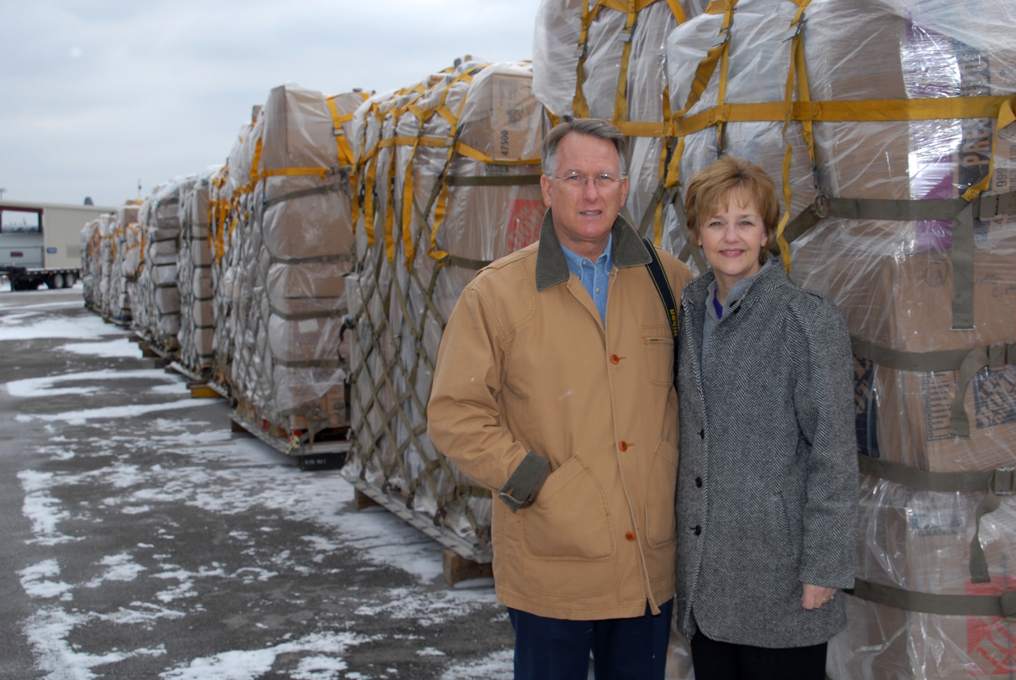 Retired Lt. Gen. John Bradley and wife Jan, who founded the Lamia Afghan Foundation, stand by a pallet at the 118th Airlift Wing. The pallets are loaded with humanitarian aid to send to people in Afghanistan. More than 60,000 pounds of aid are to be flown to Afghanistan Mid-January 2010. The foundation cooridinated the loading and delivery of the pallets. 