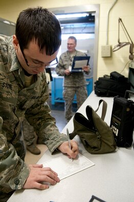 From left Staff Sgt. Danny Stone, Nondestructive Inspections Technician with the 130th Maintenance Squadron, Yeager Airfield, Charleston, W.Va. signs out equipment before he goes out to the aircraft, as Master Sgt. Charles Watts, LCAP Inspector, 118th Airlift Wing, Nashville, Tenn. observes in the background as part of a logistics compliance inspection program. Staff Sgt. Stone will use eddy current to scan the windshield frame fasteners of a WC-130H Hercules aircraft, Saturday, Jan. 9, 2010. (U.S. Air Force photo by Tech. Sgt. Eugene Crist/Released)