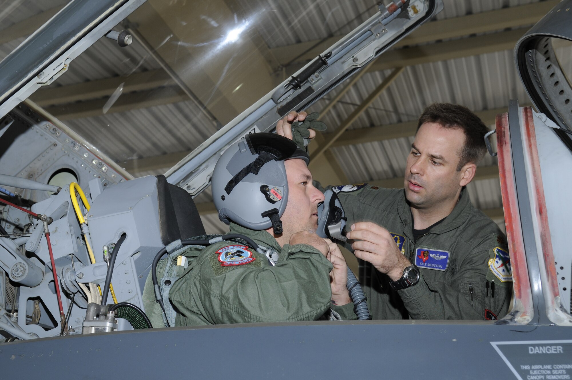 Maj. Kyle Goldstein, a T-38 pilot with the 435th Fighter Training Squadron, helps C.B. Hudson, lead guitarist for Blue October, secure his helmet before an orientation flight Jan. 12. Blue October played the July 4th concert at Ramstein Air Base, Germany, in conjunction with the United Service Organizations.  (U.S. Air Force photo/Steve White)