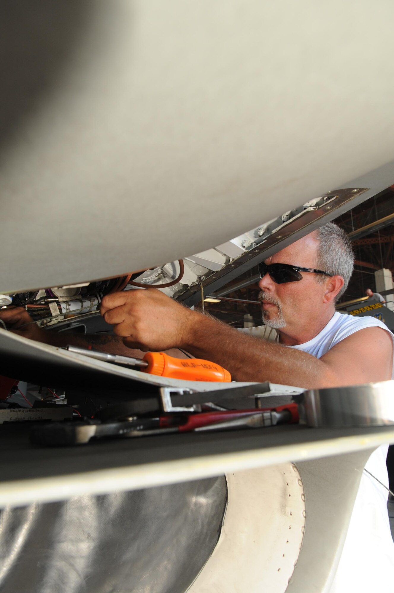 SHAW AIR FORCE BASE, S.C. -- Hugh Chamberlain, depot field team, Hill Air Force Base, Utah, installs parts on an F-16, Sept. 9. Shaw maintainers and the DFT work together to accomplish new modifications on the F-16. The beyond-line-of-sight satellite communication radios being installed allow the F-16 to utilize satellite communications to talk with units outside the line-of-sight. The end result is a greatly extended range of communication. (U.S. Air Force photo/Senior Airman David Minor)
