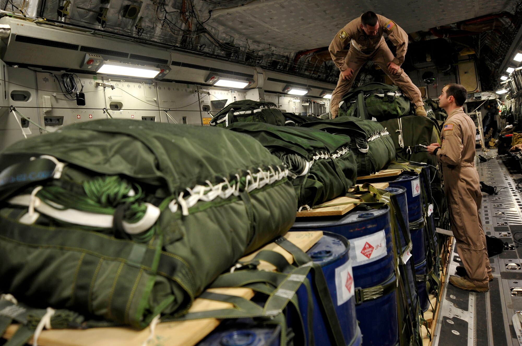 U.S. Air Force Tech. Sgt. Todd O' Bryant, 816th Expeditionary Airlift Squadron loadmaster, speaks with Staff Sgt. Jeffrey Harmon, also a loadmaster with the 816th EAS, at a deployed location in Southwest Asia. The sergeants are inspecting container delivery system bundles on board a C-17 Globemaster III that will be air dropped to ground forces in Afghanistan Jan. 9, 2010. (U.S. Air Force photo/ Staff Sgt. Angelita Lawrence) (released)