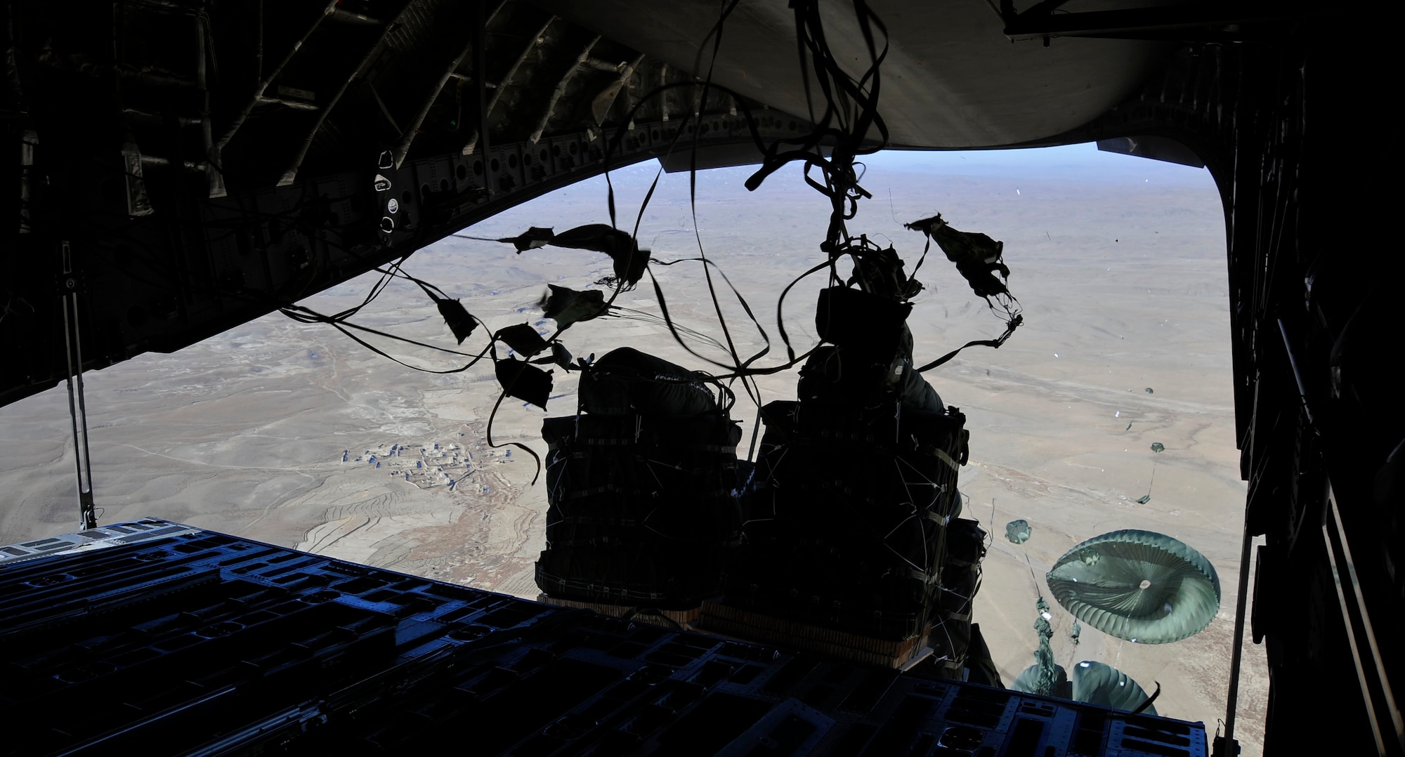 Parachutes tethered to container delivery system bundles catch air over Afghanistan after sliding off the ramp of a C-17 Globemaster III Jan. 9, 2010. Airmen from the 816th Expeditionary Airlift Squadron loaded and air dropped the bundles, which can contain supplies such as fuel, food and water needed by U.S. ground forces. (U.S. Air Force photo/Staff Sgt. Angelita Lawrence) (released)