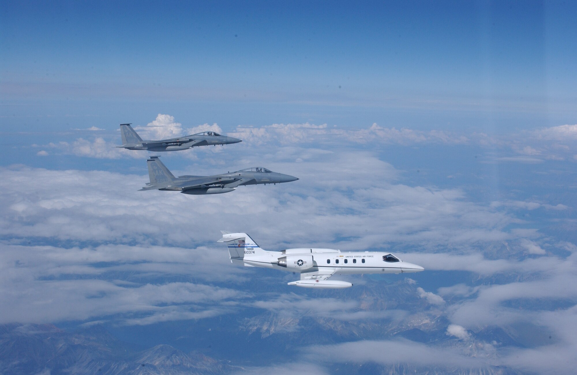 A U.S. Air Force C-21 and two F-15 Strike Eagles perform a mission near Elmendorf Air Force Base, Alaska, August 15, 2005, during Northern Edge 2005. Alaska Shield/Northern Edge 2005 is the largest homeland defense/homeland security exercise ever conducted in Alaska--the first opportunity within the state to exercise an integrated local, state and federal government response to a series of simulated emergencies including natural disasters, terrorist attacks and mass casualty scenarios. (U.S. Air Force  photo by Staff Sgt. Shane Heiser) Released
