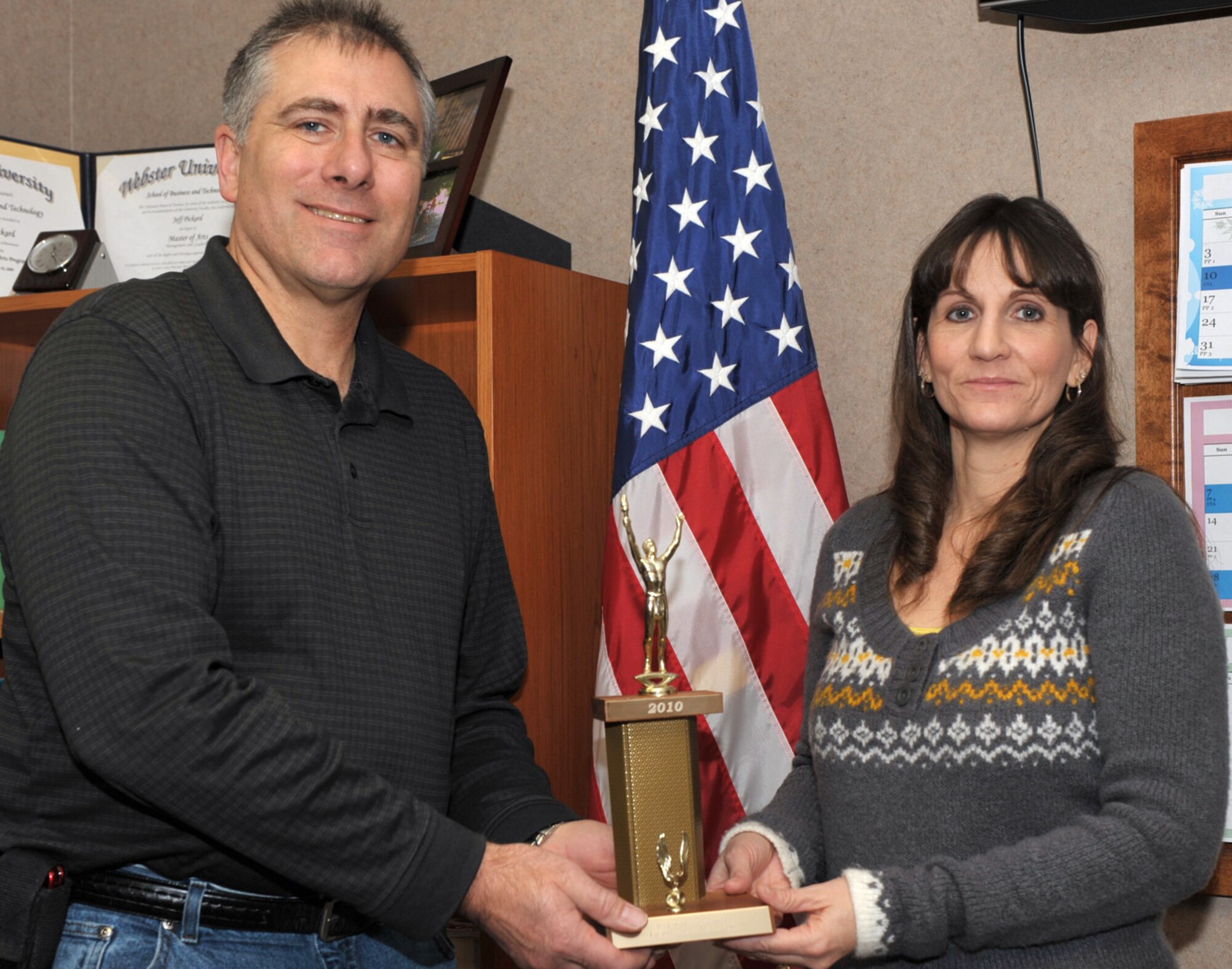 Mary Boulett receives the trophy for earning first place in the 931st Aircraft Maintenance Squadron 12th Annual Chili Cook-Off. Mrs. Boulett's "White Chili" was voted best out of 17 entries tasted during the Jan. 10 event, to include an entry from her husband, AMXS's Chief Master Sgt. John Boulett. Coming in second and third were Chief Master Sgt. Kurt Smith, 931st Civil Engineer Squadron, and Tech. Sgt. Dave Sevart (also pictured), 931st AMXS, respectively. (U.S. Air Force photo)