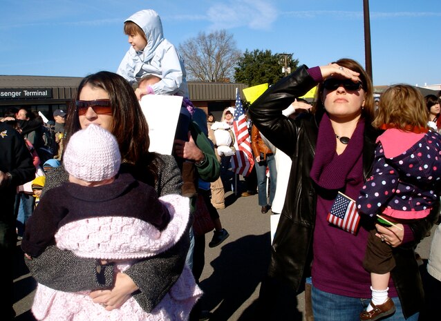Jill Masters and Tristah Bowyer try to spot their husbands as they come off of the plane on the flightline here Jan. 3. The 17th Airlift Squadron returned home from their 120-day deployment in the Middle East where they supported Operations Iraqi and Enduring Freedom as well as the Horn of Africa. Mrs. Masters is the wife of Capt. Nick Masters and Mrs. Bowyer is the wife of Capt Brad Bowyer, who are both pilots with the 17 AS(U.S. Air Force photo/Trisha Gallaway)