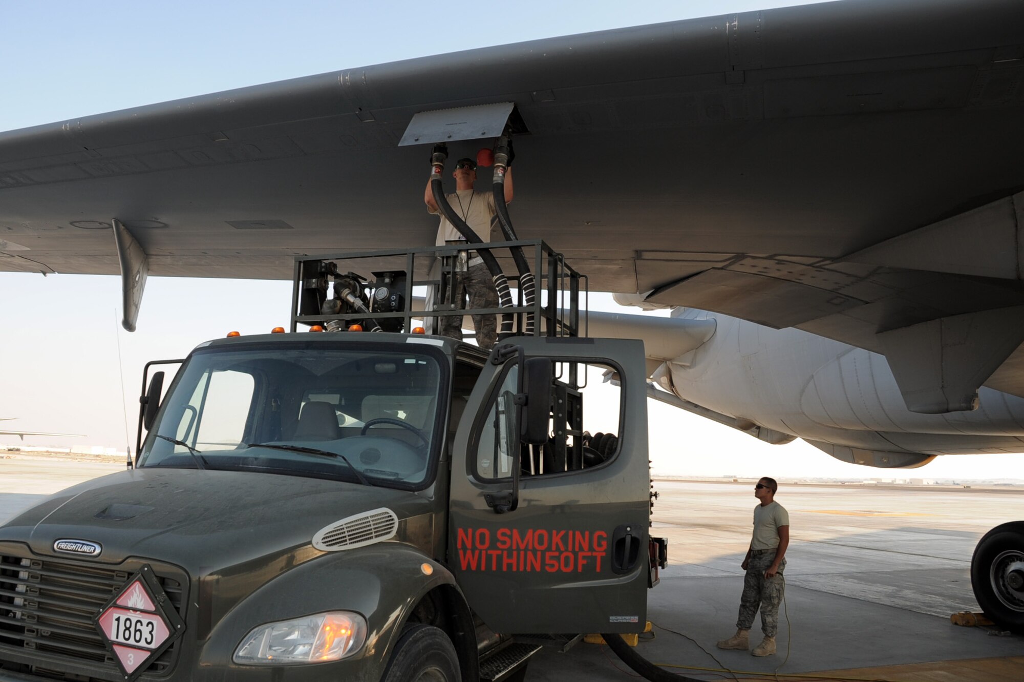 Airman 1st Class Dustin Hathcock, KC-10 Extender crew chief deployed from Travis Air Force Base, Calif., and Airman Jose Goitia, deployed from the 97th Logistics Readiness Squadron, work together to refuel a KC-10 during flightline operations at a non-disclosed base on Jan. 6, 2010. Airman Goitia and the 380th Expeditionary Logistics Readiness Squadron fuel management flight are responsible for all refueling operations for the 380th AEW.  In 2009, the flight pumped more than 188 million gallons of fuel fuel supporting operations. (U.S. Air Force Photo/Tech. Sgt. Scott T. Sturkol/Released)