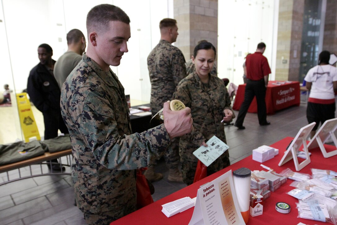 Lance Cpl. Daniel Cline, administrative clerk, 1st Marine Division, investigates the harmful effects of tobacco during Camp Pendleton’s Marine Corps Community Services health fair at the Paige Fieldhouse fitness center, Jan 13. MCCS hosted the health fair to promote healthier living habits to residents living and working on base.
