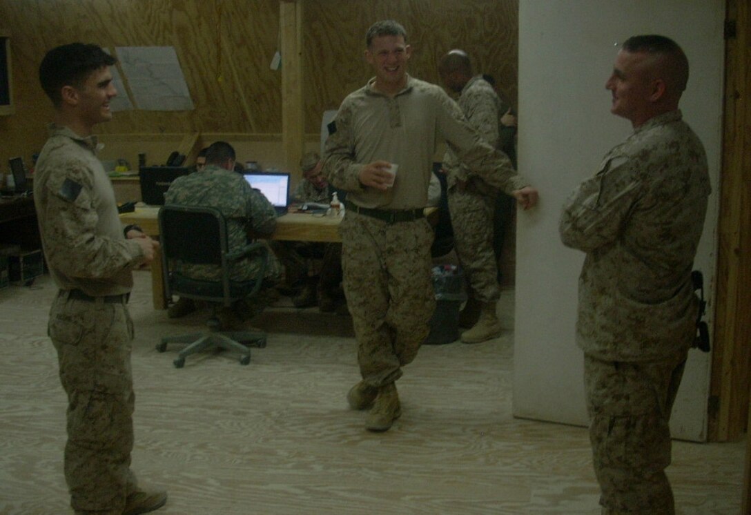 Maj. Chris Messineo (right), the logistics and supply officer for II Marine Expeditionary Force Headquarters Group (Forward), talks with 1st Lt. Sean Knapp (left) and 1st Lt. Robert Caldwell, both platoon commanders with Company B, 3rd Combat Engineer Battalion, aboard Al Asad Air Base, Iraq, Jan. 11, 2009. Knapp and Caldwell were two of Messineo’s students at the U.S. Naval Academy, and the three were reunited aboard Al Asad while deployed in support of Operation Iraqi Freedom.