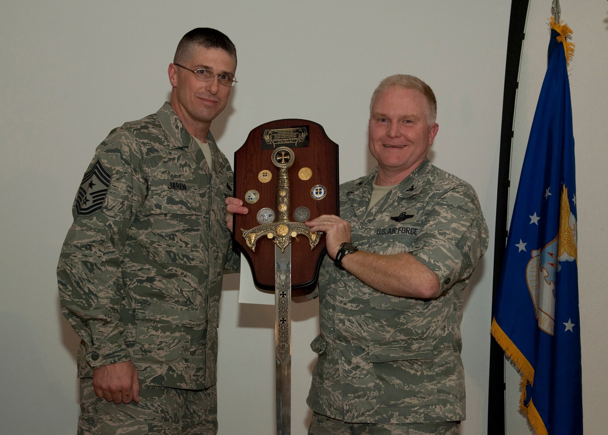 Col. Jerry Gandy, 95th Air Base Wing commander, presents Chief Master Sgt. Eric Jaren, 95th Air Base Wing command chief master sergeant with a plaque at the chief's farewell party. Chief Jaren is leaving Edwards to become the command chief master sergeant at Headquarters Air Force Materiel Command, located at Wright-Patterson Air Force Base, Ohio. (U.S. Air Force photo/Mike Yncera)