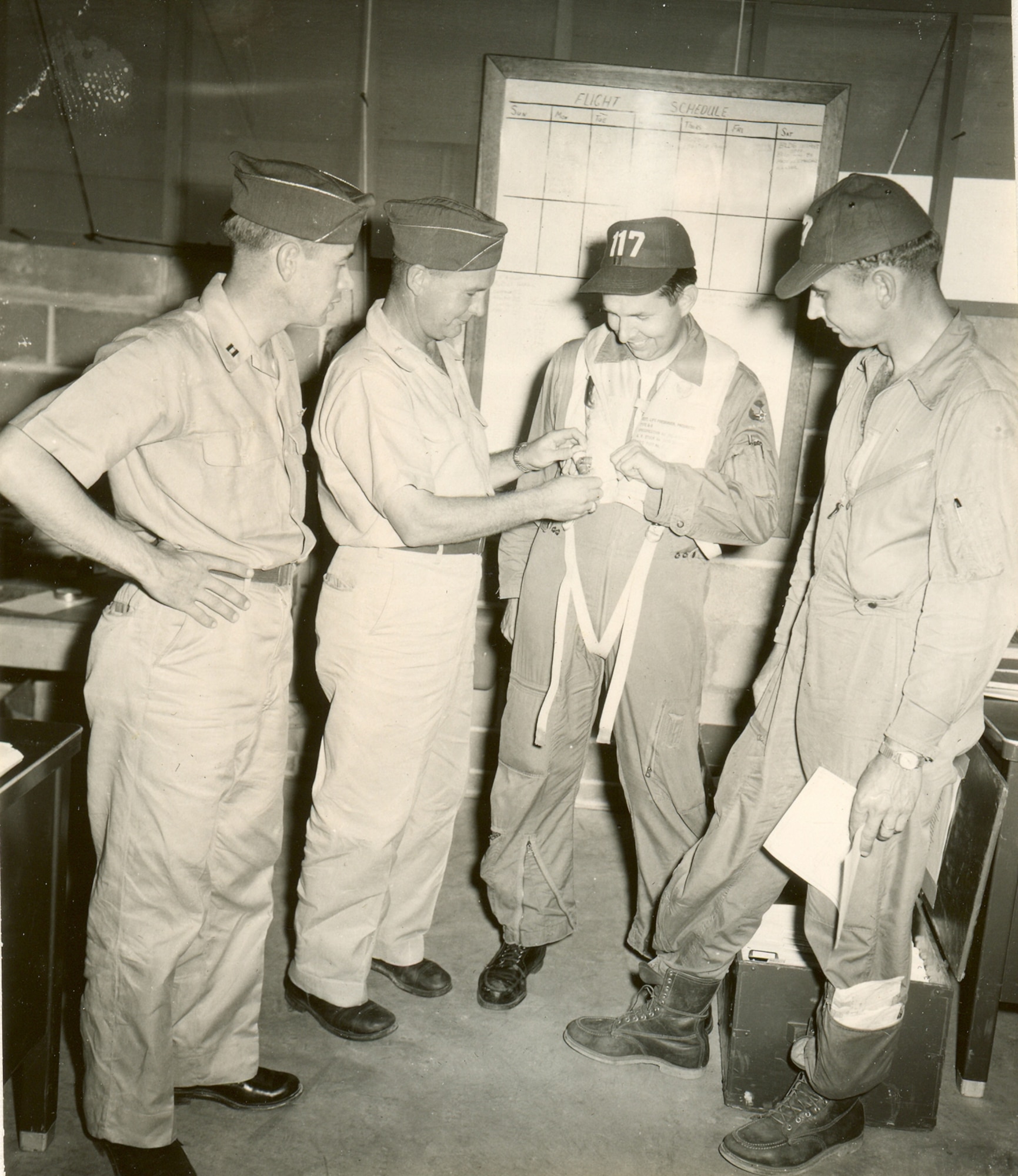 Captain Bill Fry (center with harness) and Lt. Gene Crackle (far left) had been the first two pilots to sign up for the new squadron to be formed at Hutchinson.
