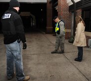 Senior Airman Warren Galligher, center, demonstrates how to perform the walk and turn portion of a field sobriety test at the Rivers Avenue main gate while Investigator Kyle Lazarus, left, monitors the test Jan. 10. The test checks abilities such as balance and the ability to follow directions. Airman Galligher is a patrolman, and both he and Investigator Lazarus are with the 628th Security Forces Squadron. (U.S. Air Force photo/Senior Airman Katie Gieratz)