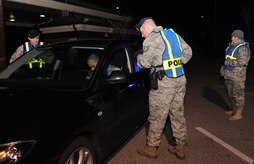Patrolmen with the 628th Security Forces Squadron conduct a mandatory sobriety checkpoint screening at the Dorchester Road main gate in the early morning Jan. 10. The checkpoint was conducted as part of the commander directed Operation Sober Roads 2. (U.S. Air Force photo/Senior Airman Katie Gieratz)