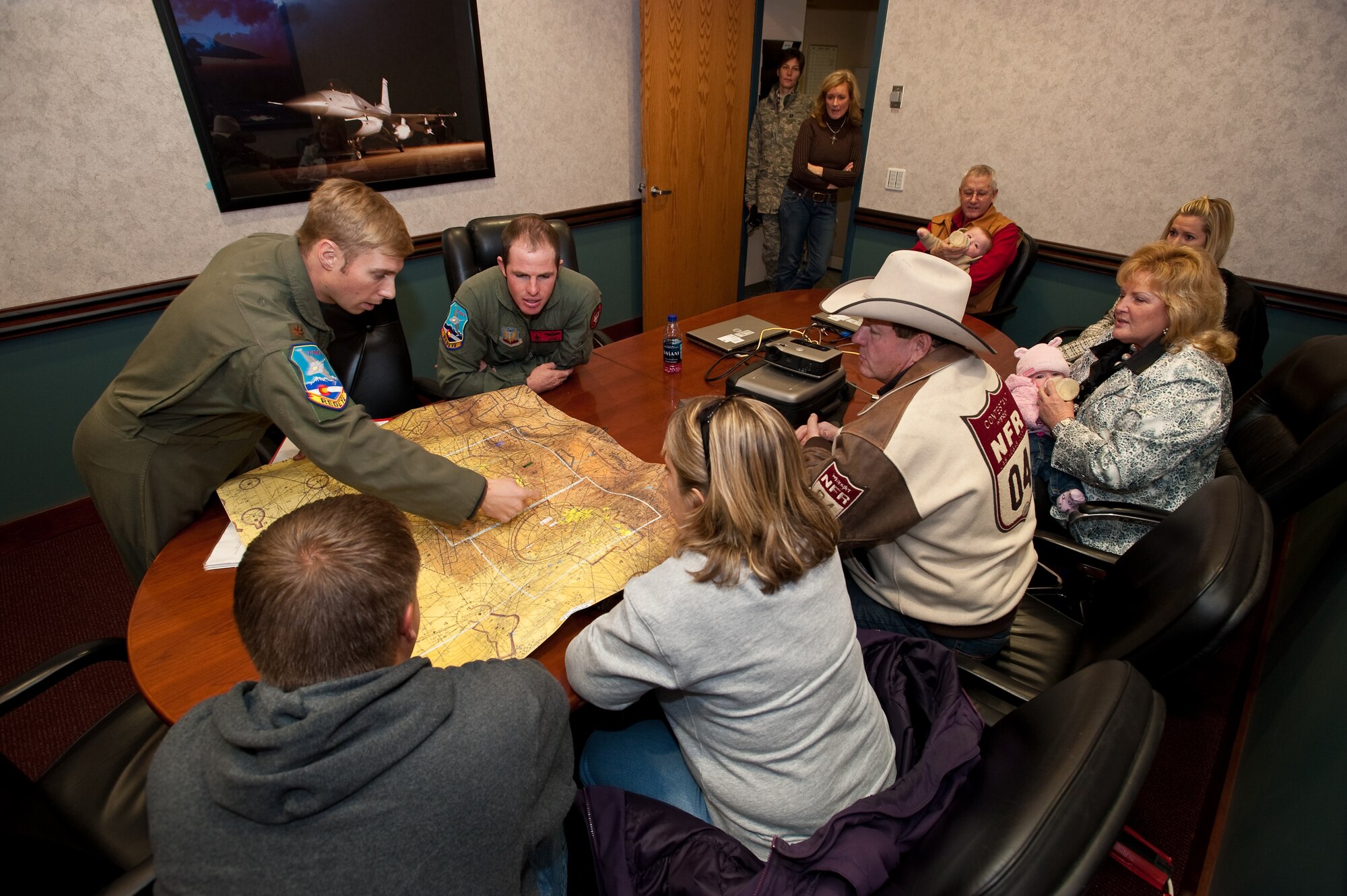 U.S. Air Force Major Marc 'Kidd' Garceau, F-16 fighter pilot, 120th Fighter Squadron, Buckley Air Force Base, describes the route they wil fly to Pro Rodeo Cowboy Association rider Josh Peek and his family prior to his orientation flight, Jan 8, 2010.  (U.S. Air Force photo/Master Sgt. John Nimmo, Sr.) (RELEASED)

