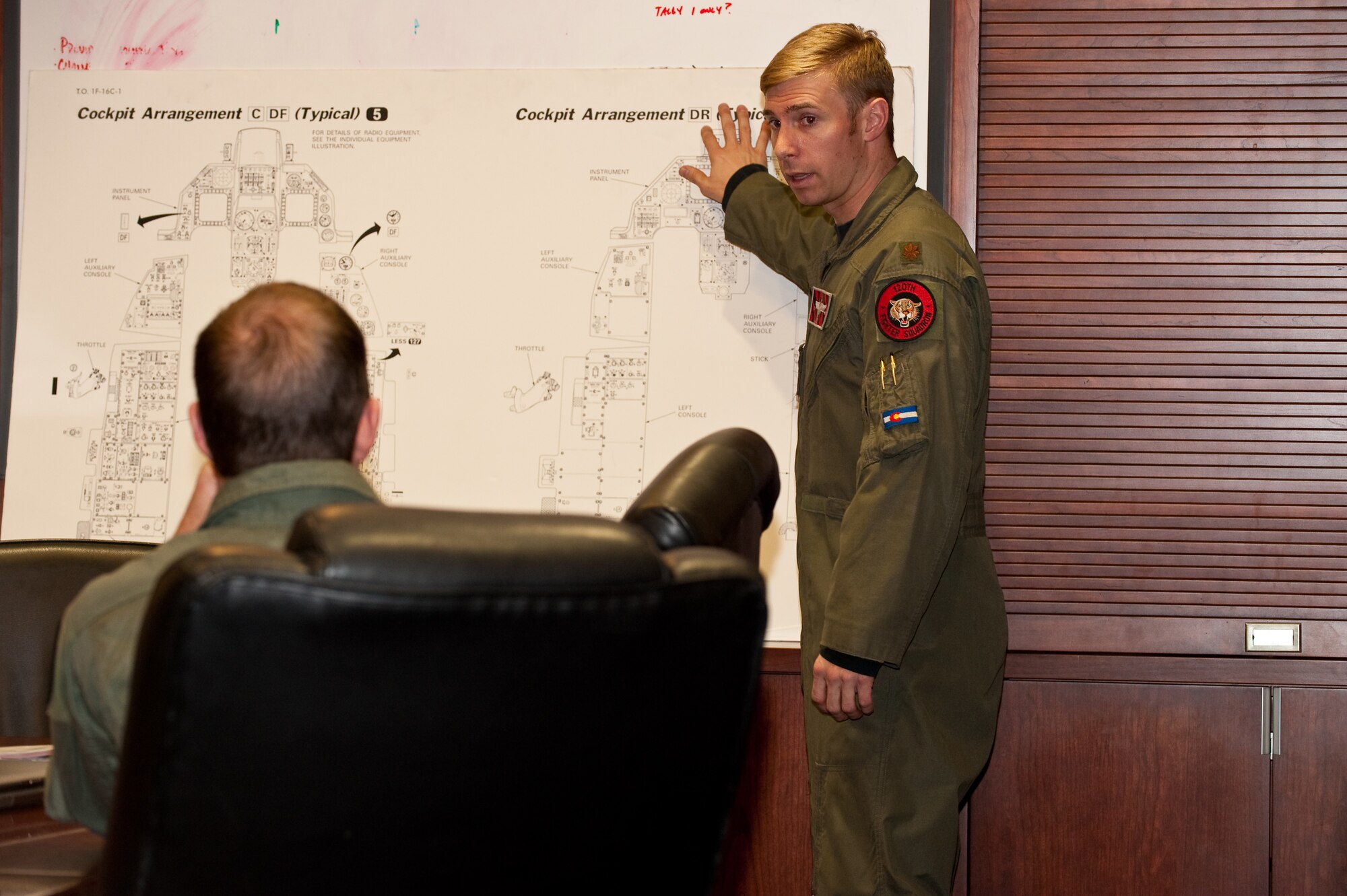 U.S. Air Force Major Marc 'Kidd' Garceau, F-16 fighter pilot, 120th Fighter Squadron, Buckley Air Force Base, briefs Pro Rodeo Cowboy Association rider Josh Peek on the arrangement of the F-16 cockpit, Jan 8, 2010.  (U.S. Air Force photo/Master Sgt. John Nimmo, Sr.) (RELEASED)

