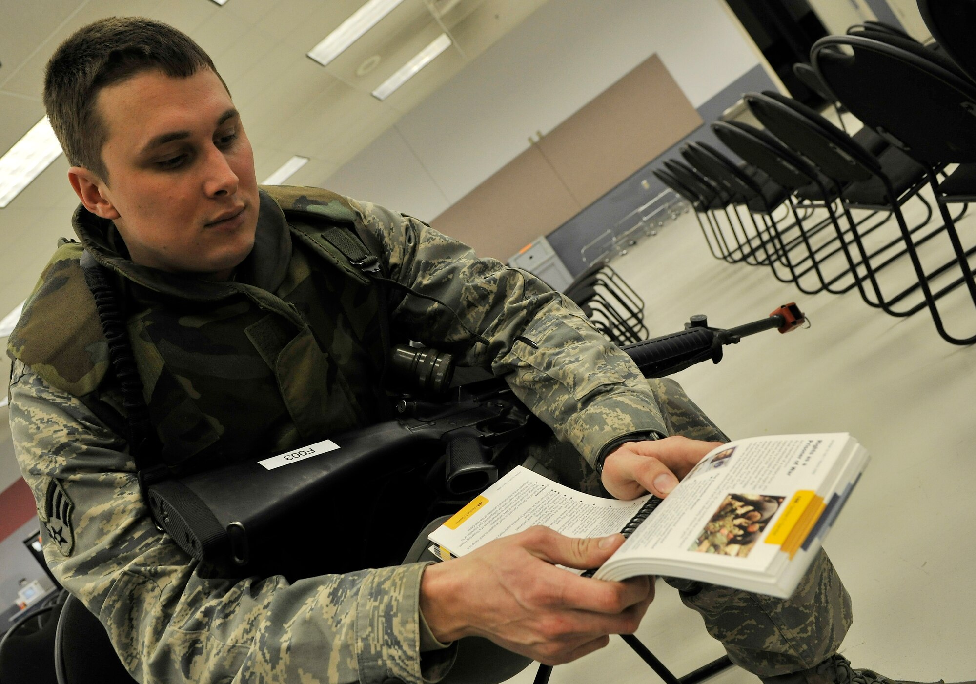 Senior Airman Kelsey Helmuth reviews his Airman's Manual during an exercise at the Joint Mobility Center Jan. 11, 2010, Eielson Air Force Base, Alaska. The exercise tests Eielson's capability to conduct operations during a wartime scenario. Airman Helmuth is assigned to the 354th Civil Engineering Squadron. (U.S. Air Force photo/Staff Sgt. Christopher Boitz)