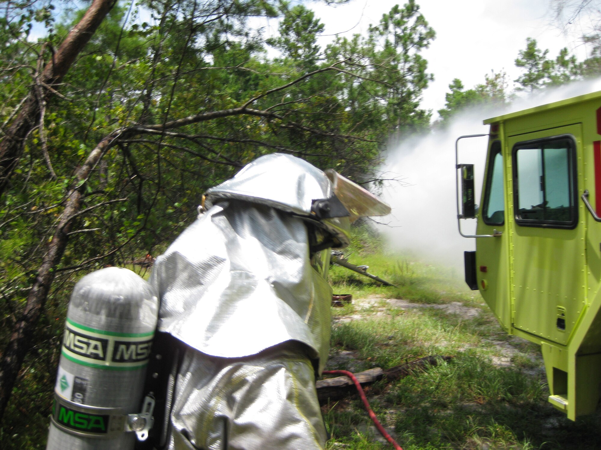 A firefighter from the 180th stands by while the P-19 Crash truck simulates putting out spot fires while participating in the Silver Flag training exercise at Tyndall AFB, FL in July, 2009.