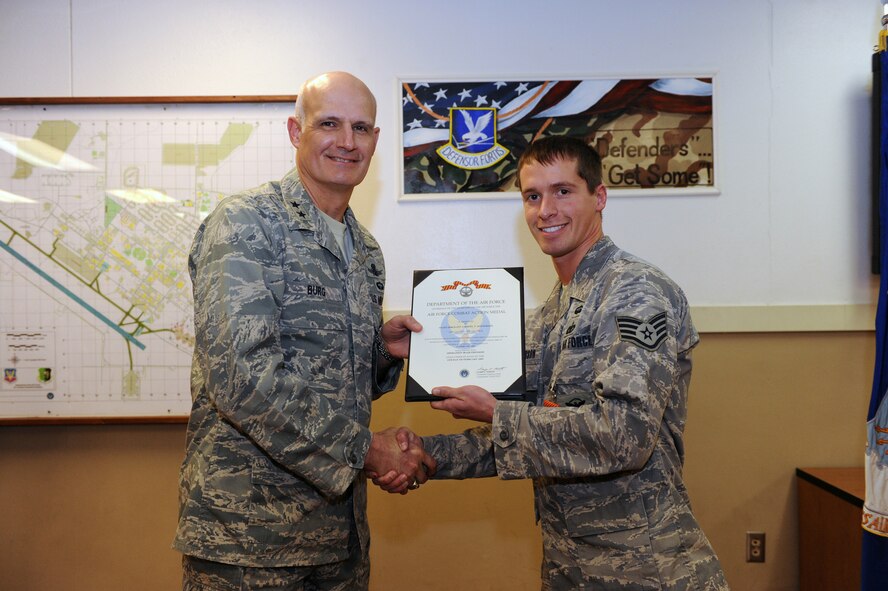 MINOT AIR FORCE BASE, N.D. -- Maj. Gen. Roger W. Burg, 20th Air Force commander, presents Staff Sgt. Gabriel T. Masterson, 791st Missile Security Forces Squadron support flight chief, with the Air Force Combat Action Medal here Jan 12. General Burg was here for a wing visit and to support an orientation visit of Senate staff members from states involved with ICBM bases. Sergeant Masterson received the medal when he was deployed to Balad Air Base, Iraq, attached to Task Force 1041 as a turret gunner on an offensive patrol off base. His patrol was ambushed by two improvised explosive device attacks within four hours where he successfully defended against hostile enemy forces. The principal eligibility criterion to receive the medal is that the individual must have been under direct and hostile fire while operating in unsecured space (outside the defended perimeter), or physically engaging hostile forces with direct and lethal fire. (U.S. Air Force photo by Senior Airman Jesse Lopez)