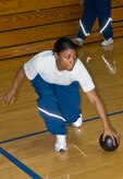 Senior Airman Gina Oliveras grabs up a lose ball while eyeing the air for flying objects during a dodgeball game at the Fitness and Sports Center here Jan. 11. More than 30 students and instructors from the Airman Leadership School and First Term Airmen Center teamed up to hold the game as a fun fitness challenge. Airman Oliveras is an ALS student. (U.S. Air Force photo/Staff Sgt. Daniel Bowles)
