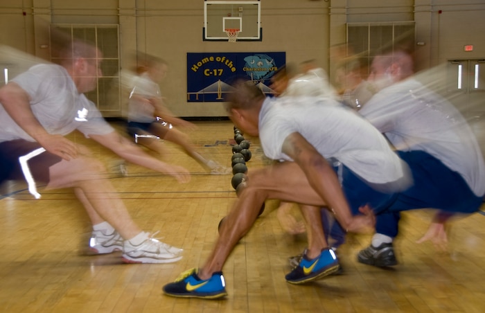 Students and instructors from the Airman Leadership School and First Term Airmen Center race to the center line of the court to retrieve a ball during a dodgeball game at the Fitness and Sports Center here Jan. 11. The two organizations hold regular fitness challenges and competitions to promote a positive, team building experience, while boosting the fun of their physical training. (U.S. Air Force photo/Staff Sgt. Daniel Bowles)