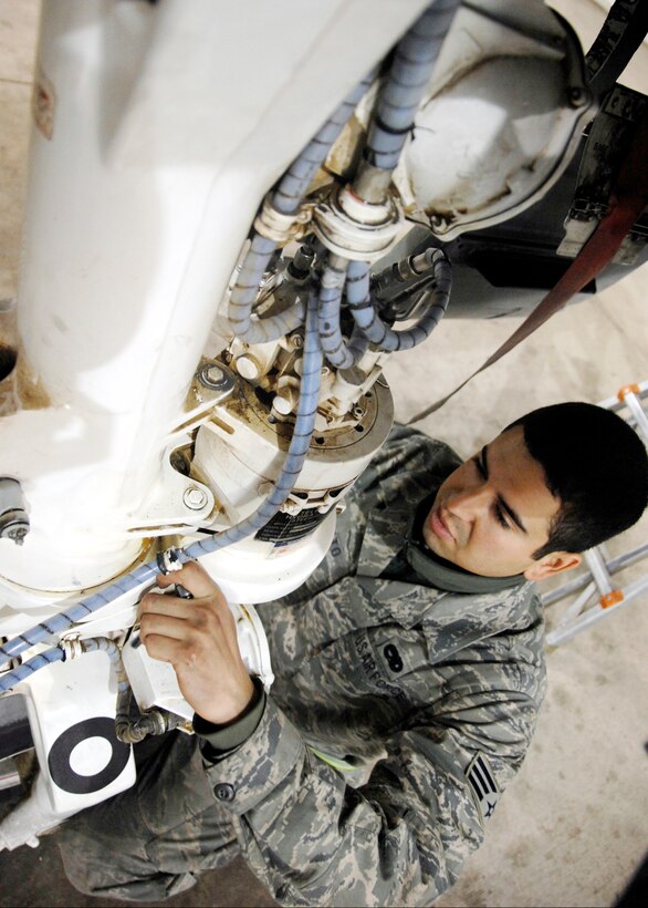 Senior Airman Julio Morato adjusts the taxi light wire harness attached to the nose wheel steering unit cover Dec. 10, 2009, at Kandahar Airfield, Afghanistan. Airman Morato is a 451st Expeditionary Maintenance Squadron maintenance flight crew chief. (U.S. Air Force photo/senior Airman Timothy Taylor)