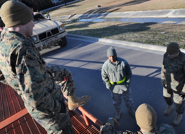 Tech. Sgt. Adrian Dailey, center, speaks to a group of Marines from the 4th Landing Support Battalion about new procedures being put into place for vehicle cargo loading here Jan. 5. The 437th Aerial Port Squadron cargo services center began shipping M-ATVs in September and will continue working with the Marines to prepare M-ATV shipments into the spring. Sergeant Dailey is the NCOIC of cargo services. (U.S. Air Force photo/Senior Airman Katie Gieratz)(RELEASED)
