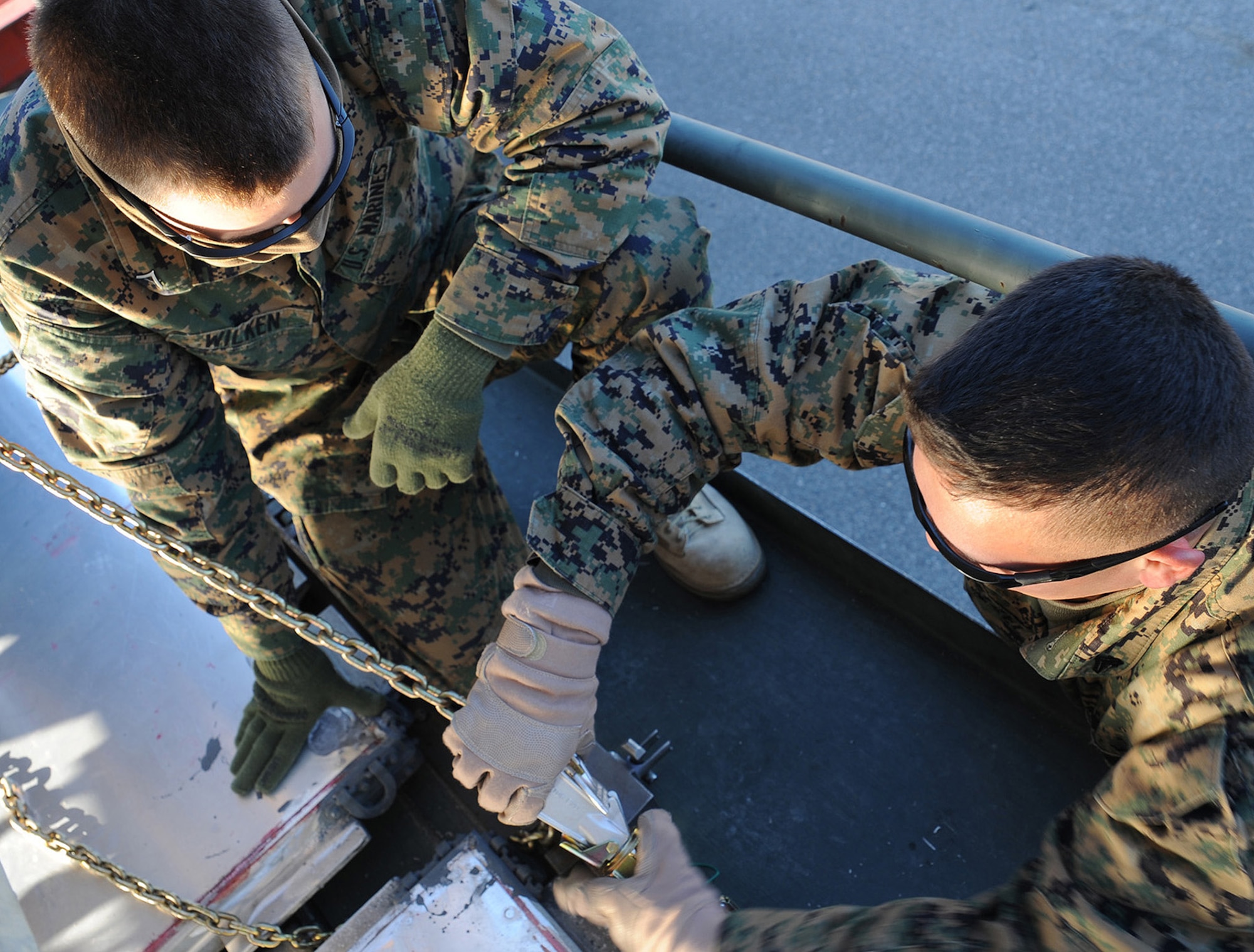 Marine Cpl. Matt Netzel assists Marine Lance Cpl. Justin Wilken in tying down a mine-resistant, ambush-protected all-terrain vehicle to a support pallet here Jan. 5. The two Marines are part of a team who operates out of Charleston AFB to assist in preparing M-ATVs for shipment. Corporals Netzel and Wilken are landing support specialists with the 4th Landing Support Battalion. (U.S. Air Force photo/Senior Airman Katie Gieratz)(RELEASED)
