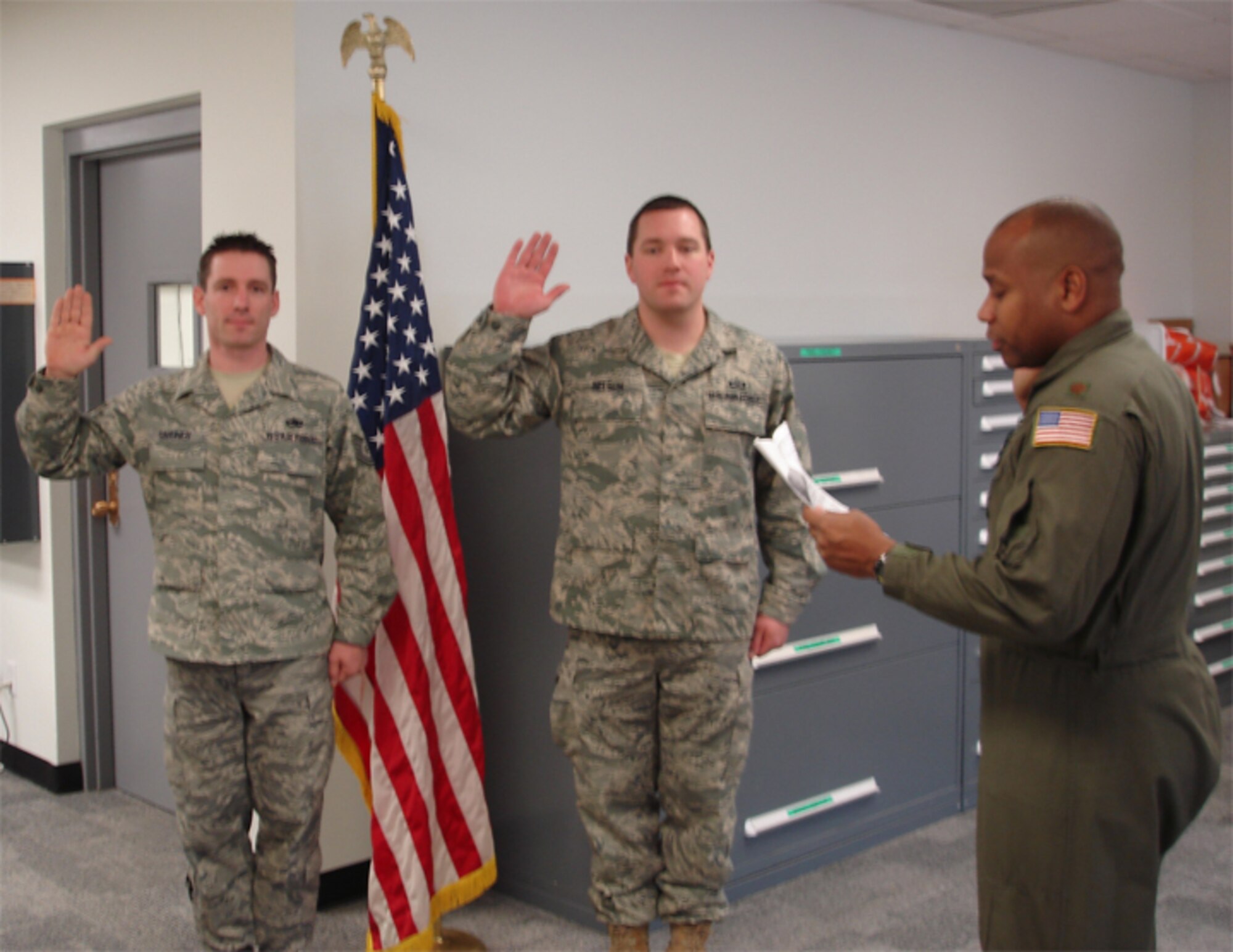 Tech. Sgts. Ian Gardner (left) and TJ Nelson re-enlist during the January unit training assembly. Both are reservists with the 916th Air Refueling Wing Aircrew Flight Equipment shop. Maj. Don Dunn, pilot, issues the oath of re-enlistment.