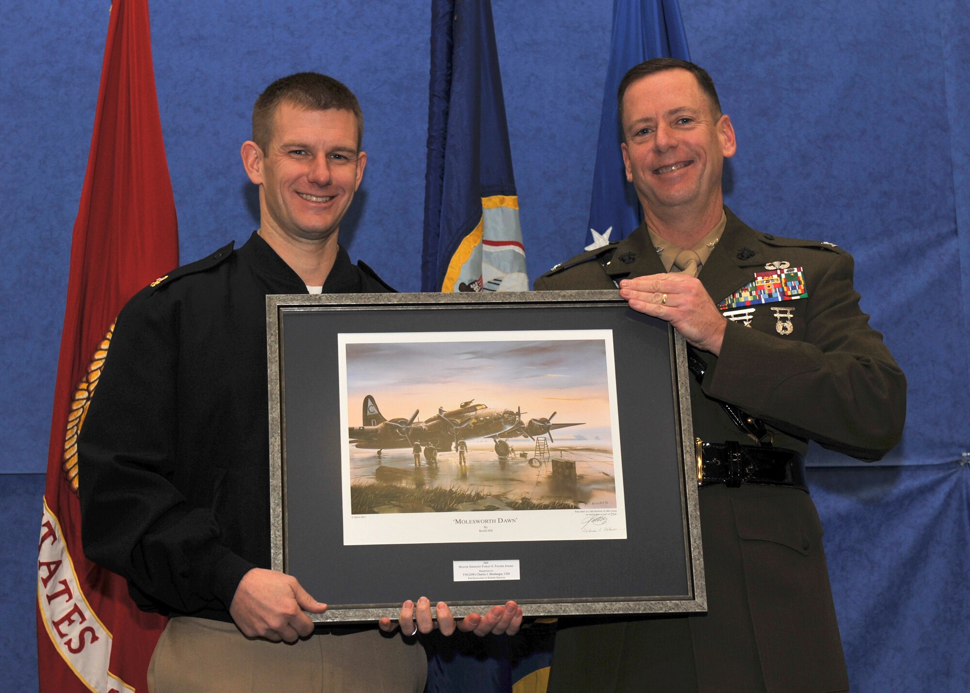 Navy Chief Petty Officer Charles J. Mosbarger receives the first Master Sgt. Fabian S. Folmer Award from JAC Commander, Marine Corps Col. Pete Devlin in a January 8, 2010 ceremony.  Mosbarger is NCOIC of the JAC Personnel Division.  The award honors the crew chief of the famed B-17 "Hell's Angels" of the 303rd Bomb Group (Heavy) who is depicted in the painting presented to Mosbarger. U.S. Air Force photo by Staff Sgt. Javier Cruz