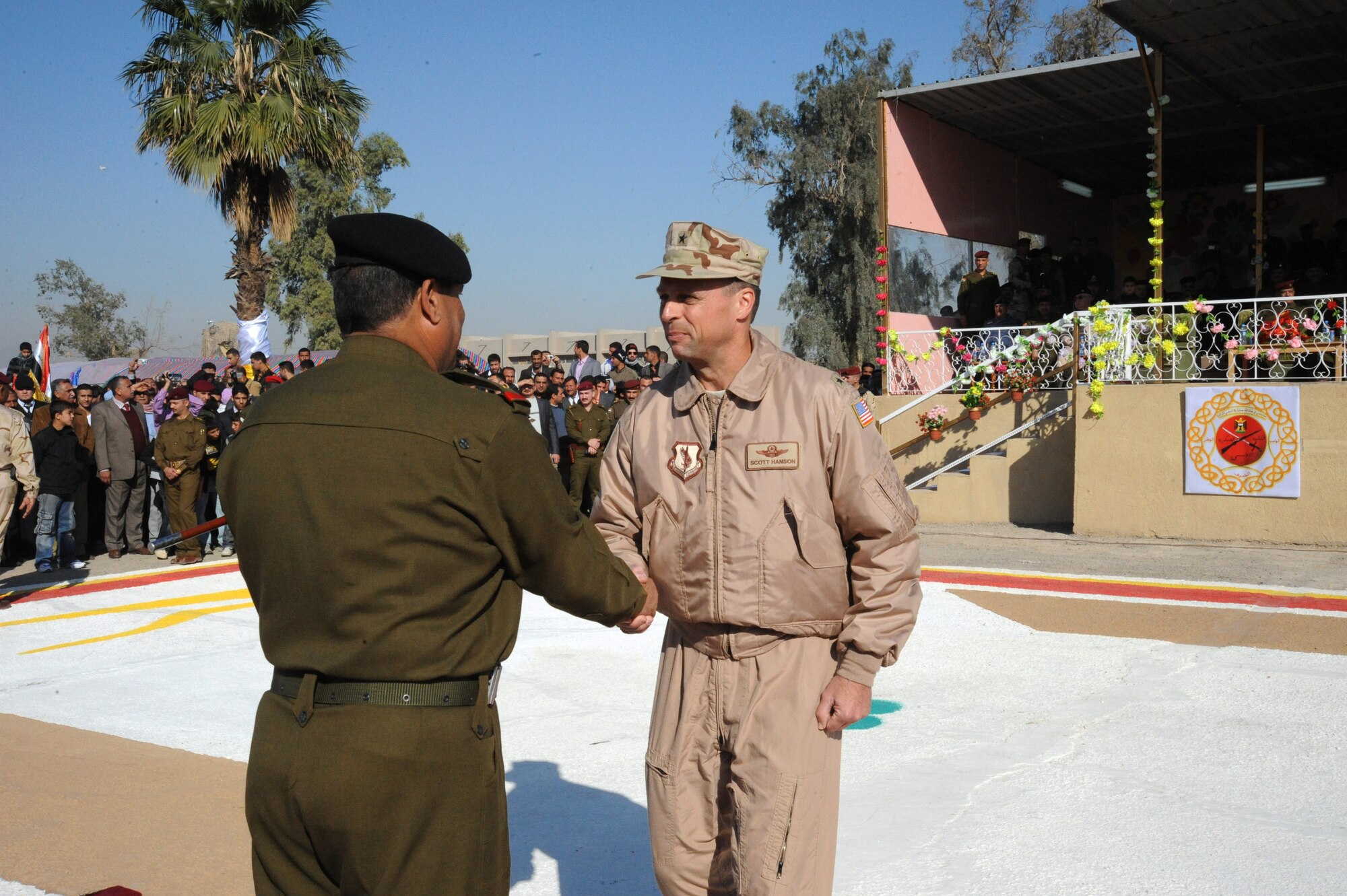 U.S. Air Force Brig Gen. Scott Hanson, commander of the 321st Air Expeditionary Wing, shakes hands with Staff Major General Majeed Hassam Zqat, commandant of the Iraqi Military Academy-Rustamiyah, during an Iraqi air force officer graduation ceremony on IMA-Rustamiyah, Iraq, Jan 10, 2010. The Top Off course teaches recruits about rank structure, leadership and what kind of benefits they will receive. (U.S. Air Force photo/Master Sgt. Trish Bunting/ Released)