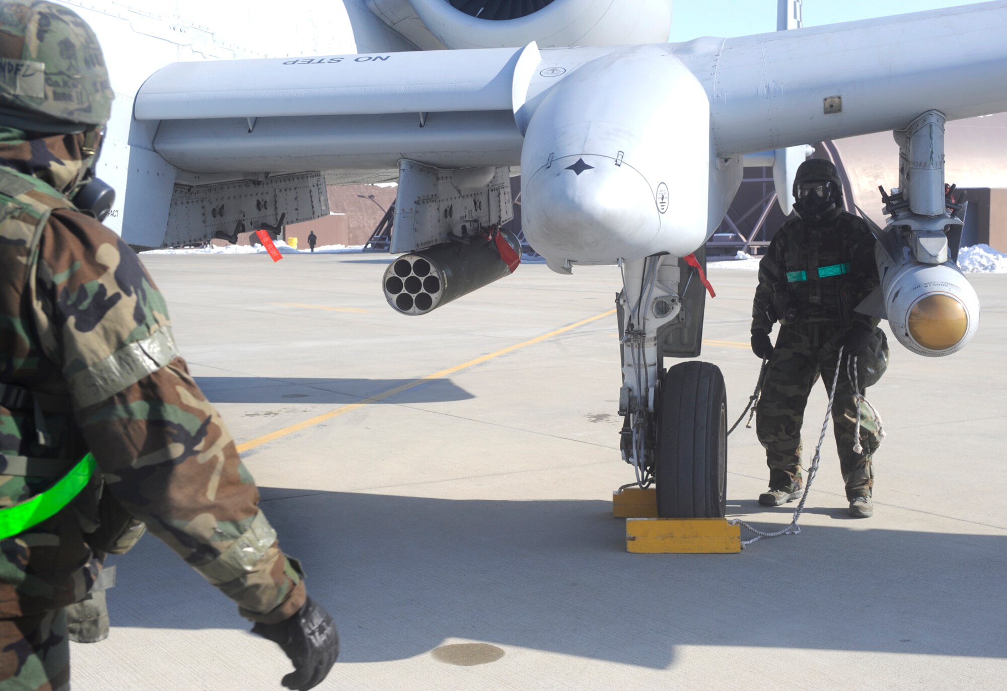 Two Airmen in Mission Oriented Protective Posture four prepare an A-10
to be taken into a 25th Fighter Squadron hangar after flight for maintenance
during Operational Readiness Exercise Beverly Bulldog 10-01 at Osan Air
Base, Republic of Korea, Jan. 13. (U.S. Air Force photo/Senior Airman
Stephenie Wade)
