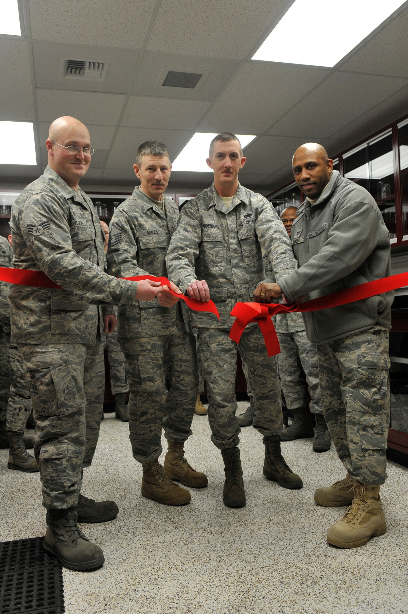 Senior Airman Christopher Coon, Master Sgt. Ronald Menges, Tech. Sgt. Jason VanDenburg and Colonel Karlton Johnson cut the ceremonial ribbon Dec. 15, 2009, at Eielson Air Force Base, Alaska. The ribbon cutting ceremony took place after six and a half months of renovating the laboratory. The end costs of the improved lab totals around $95,000. Senior Airman Coon, Sergeant Menges and Sergeant VanDenburg work in the 354th Logistics Squadron Petroleum, Oils and Lubricants flight. Colonel Johnson is the Maintenance Support Group commander. (U.S. Air Force photo/Airman 1st Class Janine Thibault)