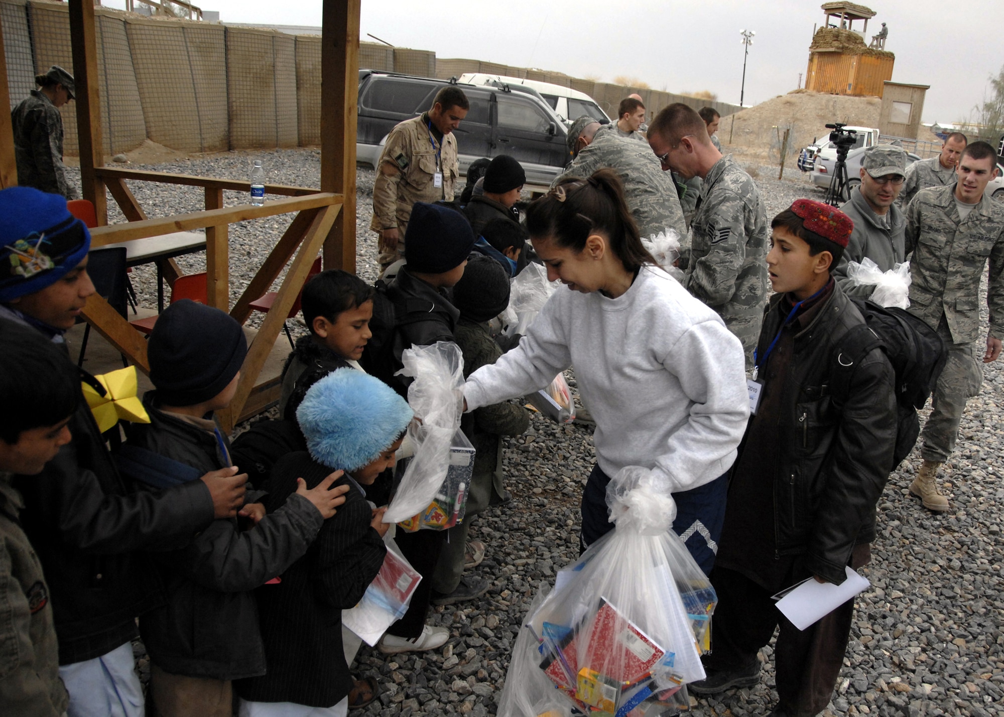 Air Force volunteers hand out bags of school supplies and goodies to Afghan students at the Kandahar Airfield Bazaar School, Jan. 2, 2010. Thousands of humanitarian aid items were collected from various agencies, families and churches in the United States. Donations were sorted and distributed to Afghan children and local villages in need of supplies. (U.S. Air Force photo/Senior Airman Timothy Taylor)