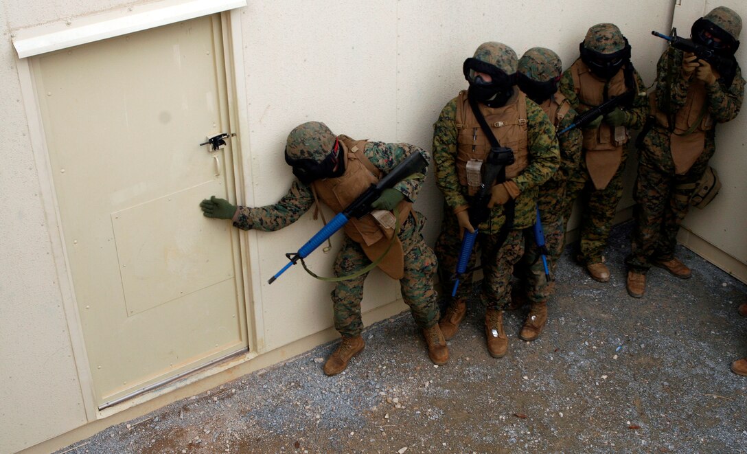 A squad of Marines stack up on a door during the casualty evacuation exercise. The pointman checked the door for traps before the squad breached the door and cleared the building of mock enemies.