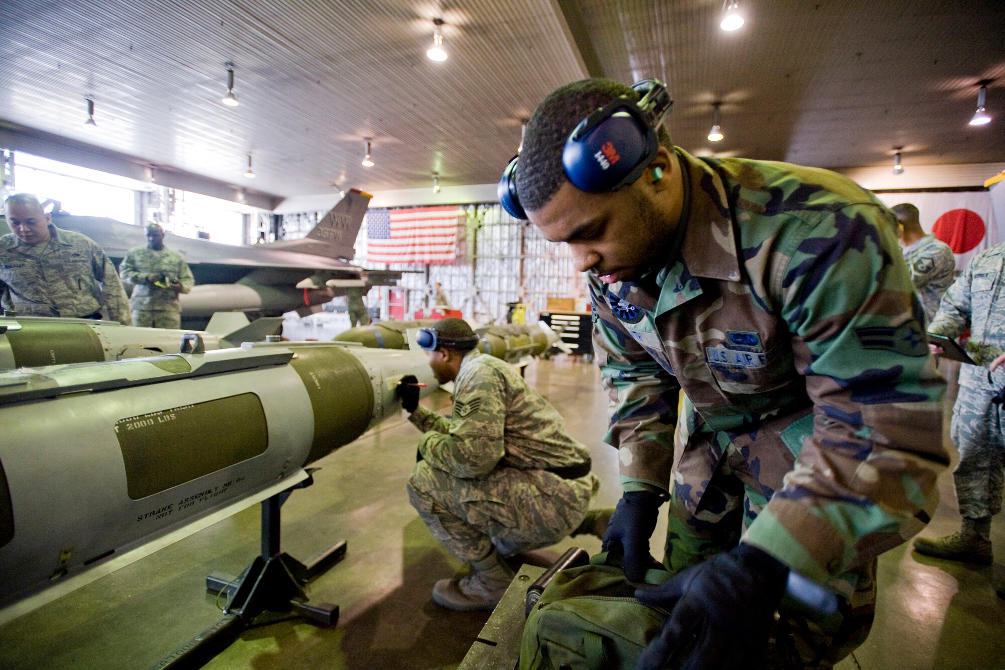 MISAWA AIR BASE, Japan -- Airman 1st Class Roderick Smith (right) inspects and installs bomb rollers as Staff Sgt. Antonio Hamilton (left) annotates bomb fuze settings during a weapons-load crew competition Jan. 13 at Hangar 911. Both are from the 14th Aircraft Maintenance Unit. (U.S. Air Force photo/Senior Airman Jamal D. Sutter)