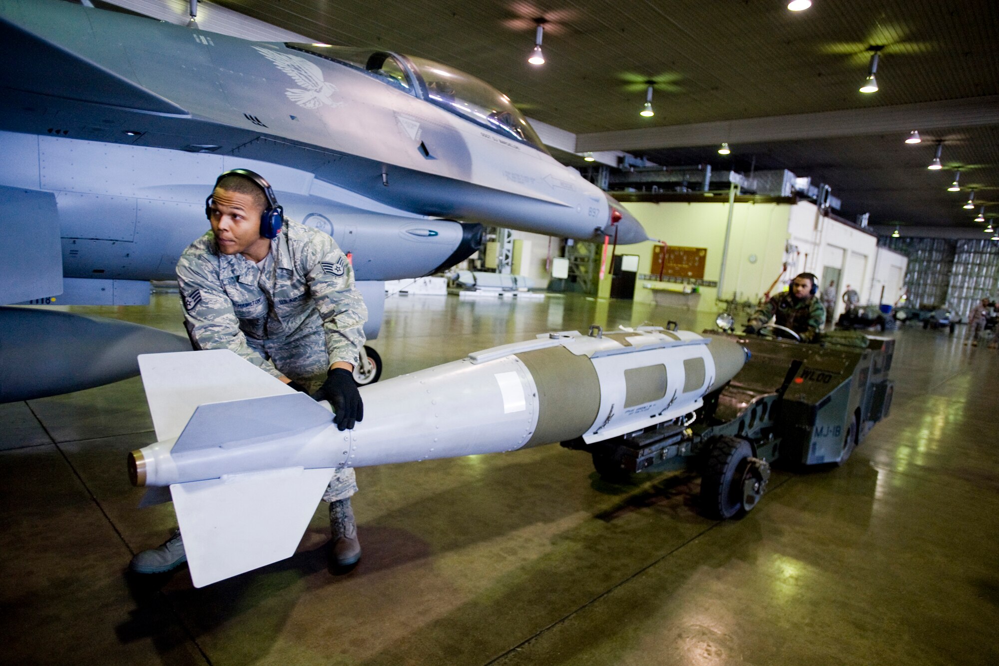 MISAWA AIR BASE, Japan -- Staff Sgt. Antonio Hamilton and Airman 1st Class Roderick Smith, 14th Aircraft Maintenance Unit load-crew members, transport a GBU-31 joint direct attack munition during a weapons-load crew competition Jan. 13 at Hangar 911. Sergeant Hamilton and Airman Smith's team, which also included Airman 1st Class Jason Wilbanks, won the competition with a load time of 12:01 and final score of 1,240 points. (U.S. Air Force photo/Senior Airman Jamal D. Sutter)