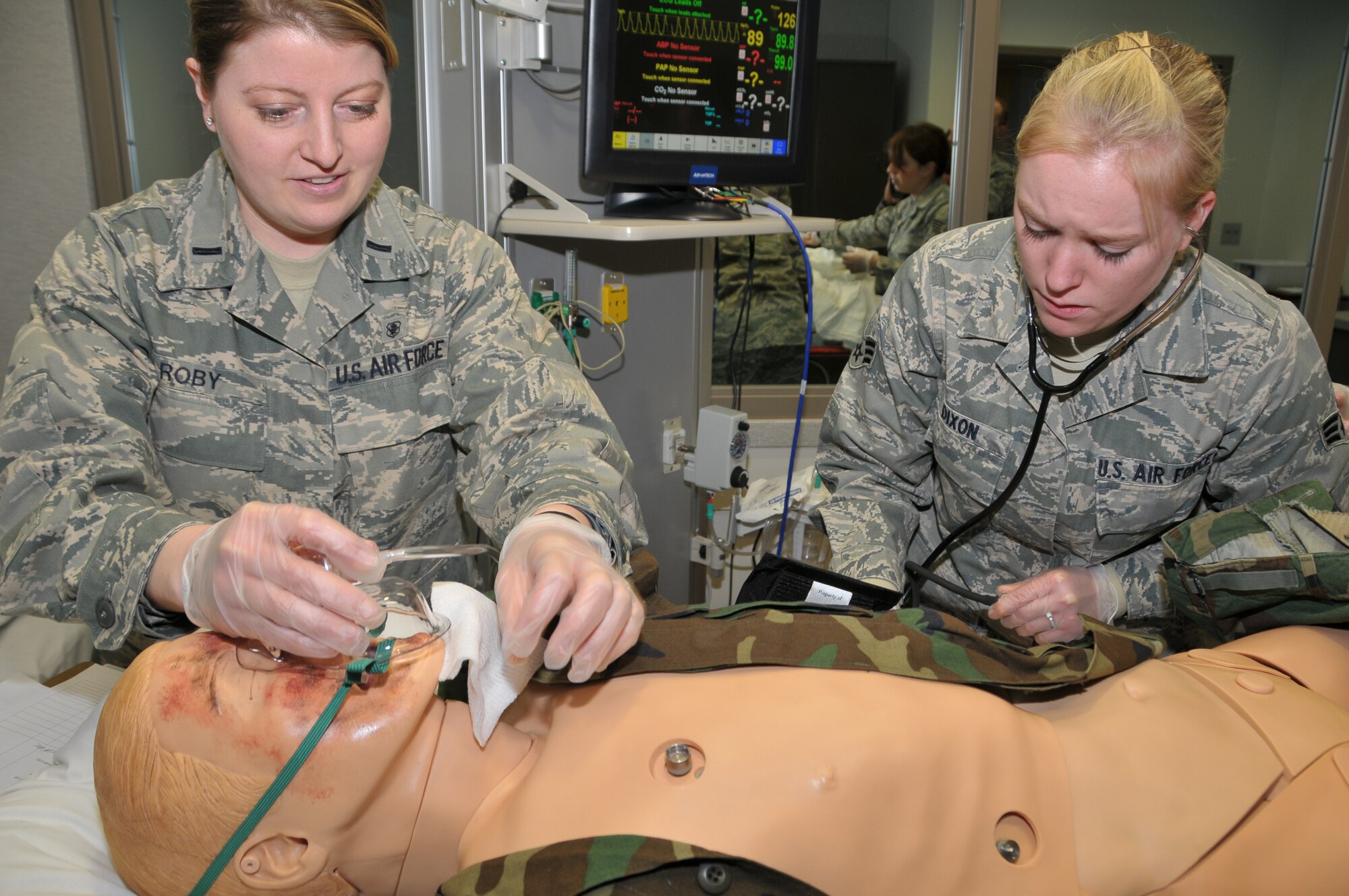 1st Lt. Amanda Roby and Senior Airman Heather Dixon from the 141st Medical Group, check for vital signs during a medical evaluation.
