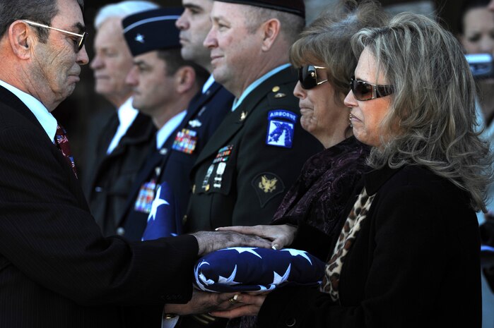 NELLIS AIR FORCE BASE, Nev.-- Navy Cmdr. (ret) Gary Thornton presents a folded American flag to Mrs. Deborah Sue Stein during the repatriation and funeral ceremony for Maj. Russel C. Goodman at the Thunderbird hanger on Nellis AFB, Jan. 14, 2010. Mrs Stein is the daughter of Maj. Goodman who served as the narrator for the U.S. Air Force Thunderbirds from 1964-65 and was declared Missing-In-Action after his aircraft was hit by a surface-to-air missile in Feb. 1967, while on a combat mission over North Vietnam.
(U.S. Air Force photo by Tech. Sgt. Michael R. Holzworth)