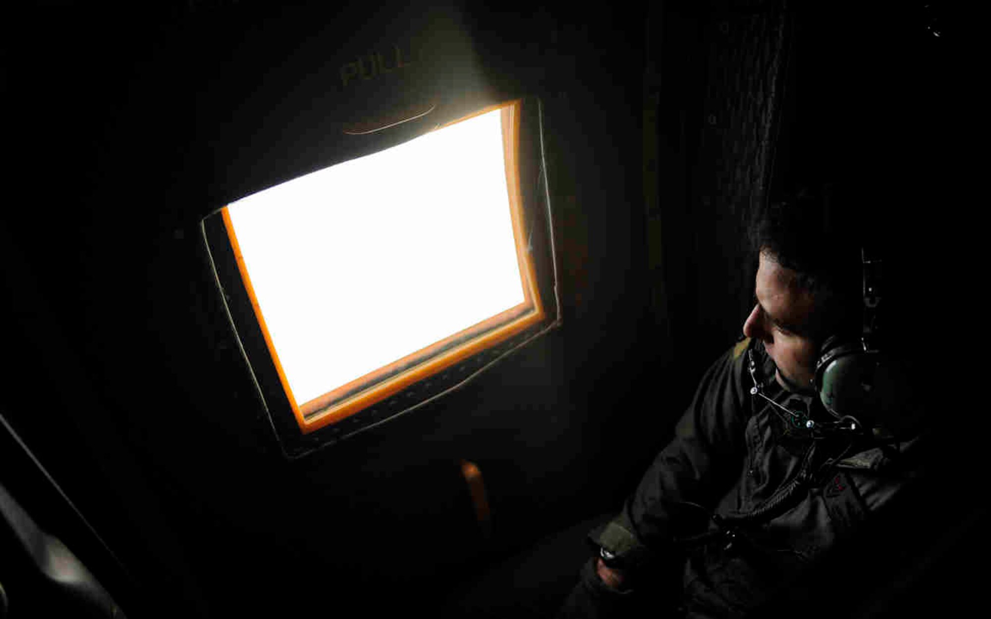 U.S. Air Force Tech. Sgt. Jon Paszkot, C-130 Loadmaster, 6th Special Operations Squadron, Hurlburt Field Fla., scans from his C-130 after takeoff from Hurlburt Field Fla., Jan. 14, 2010, en route to Haiti in support of humanitarian operations.  The U.S. Air Force is providing humanitarian assistance and disaster relief to Haiti after a magnitude 7 earthquake hit the country on Jan. 12, 2010.  U.S. Air Force photo by Tech. Sgt. James L. Harper Jr.
