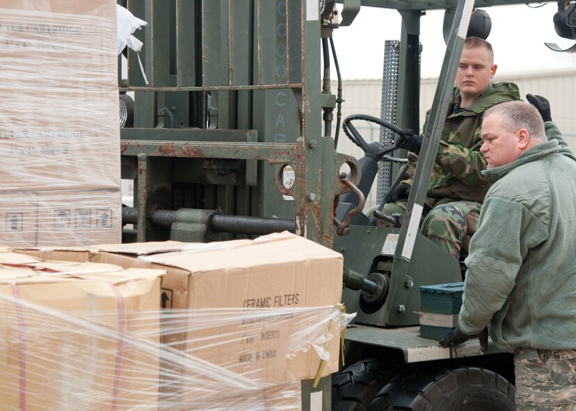 Senior Airman Sean Martin (forklift) and Master Sgt. Warren Bartee (guiding), both of the 136th Logistics Readiness Squadron, load 5,000 water filtration systems on to a pallet for load planning, Jan. 14, 2010 at NAS Fort Worth JRB, Carswell Field, Texas. The filtration systems were donated by the Texas Baptist Men to aid in the relief effort in Haiti. (U.S. Air Force Photo/Senior Airman Andrew Dumboski/ Released)