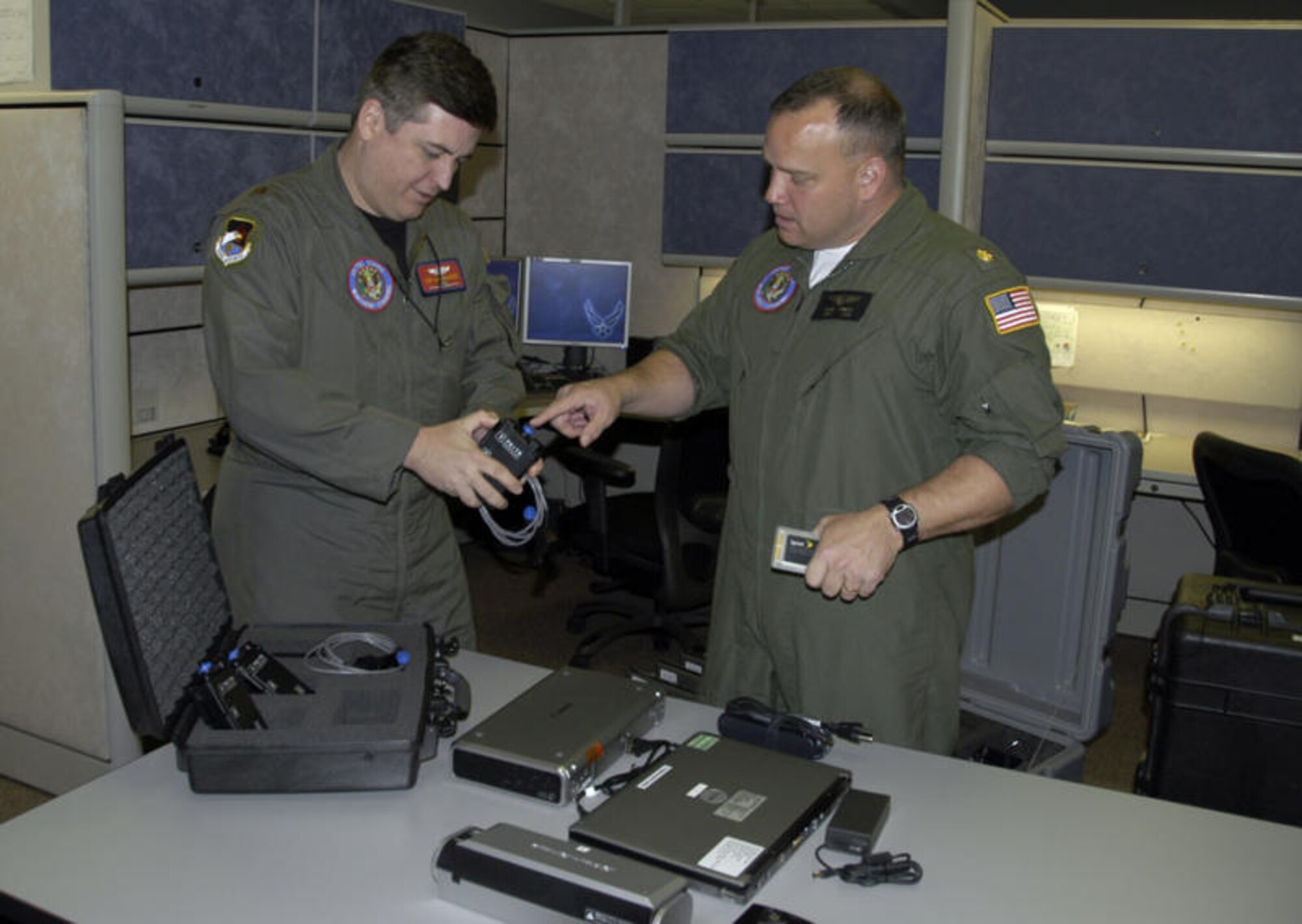 U.S. Air Force Maj. Jim Gallagher (left) and Navy Lt. Cmdr. Chris Arnett, examine Blue Force Tracking devices in preparation for Lt. Cmdr. Arnett's deployment in support of Haitian earthquake relief efforts. U.S. Air Force photo by Master Sgt. Jerry Harlan