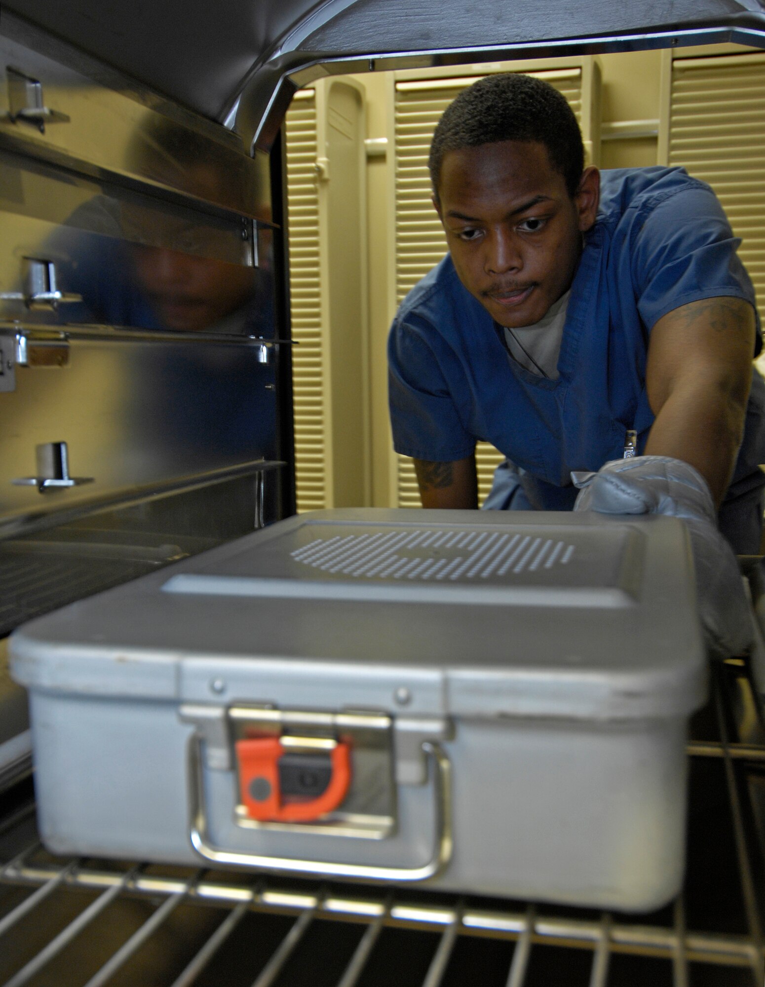VANDENBERG AIR FORCE BASE, Calif. -- With heat surrounding him, Senior Airman Dominique Cutrer, a dental technician from the 30th Medical Operations Squadron here, reaches in a steam and pressure sterilizer to remove a case of dental instruments here Jan. 12, 2010. The sterilizer heats up to 274 degrees for approximately 50 minutes.  (U.S. Air Force photo/Airman 1st Class Andrew Lee)
