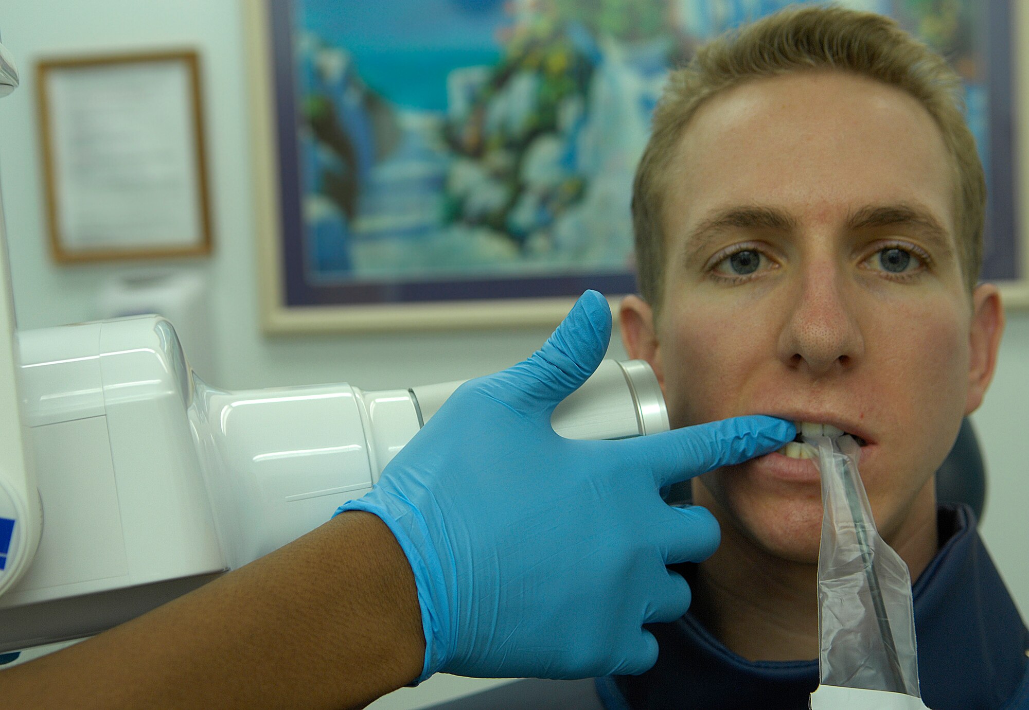 VANDENBERG AIR FORCE BASE, Calif. --  Getting prepared to be hit with a little bit of radiation, Staff Sgt. Patrick Tibbett, from the 9th Space Operations Squadron here, holds a digital X-ray sensor in his mouth here Tuesday, Jan. 12, 2010. The sensor picks up radiation emitted by the X-ray machine, which then transmits a digital image of the teeth to a monitor. (U.S. Air Force photo/Airman 1st Class Andrew Lee)
