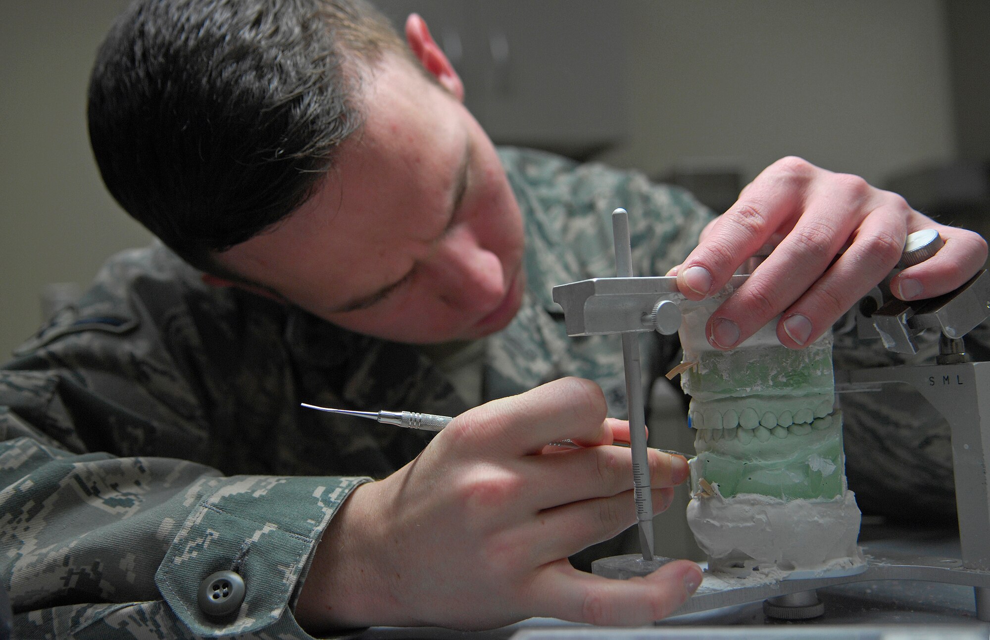 VANDENBERG AIR FORCE BASE, Calif. -- Patiently doing his job, Airman Aaron Jeffers, a dental lab apprentice from the 30th Medical Operations Squadron here, removes the imperfections from a cast of two rows of teeth to get it ready for a hard night guard here Tuesday, Jan. 12, 2010. (U.S. Air Force photo/Airman 1st Class Andrew Lee)
