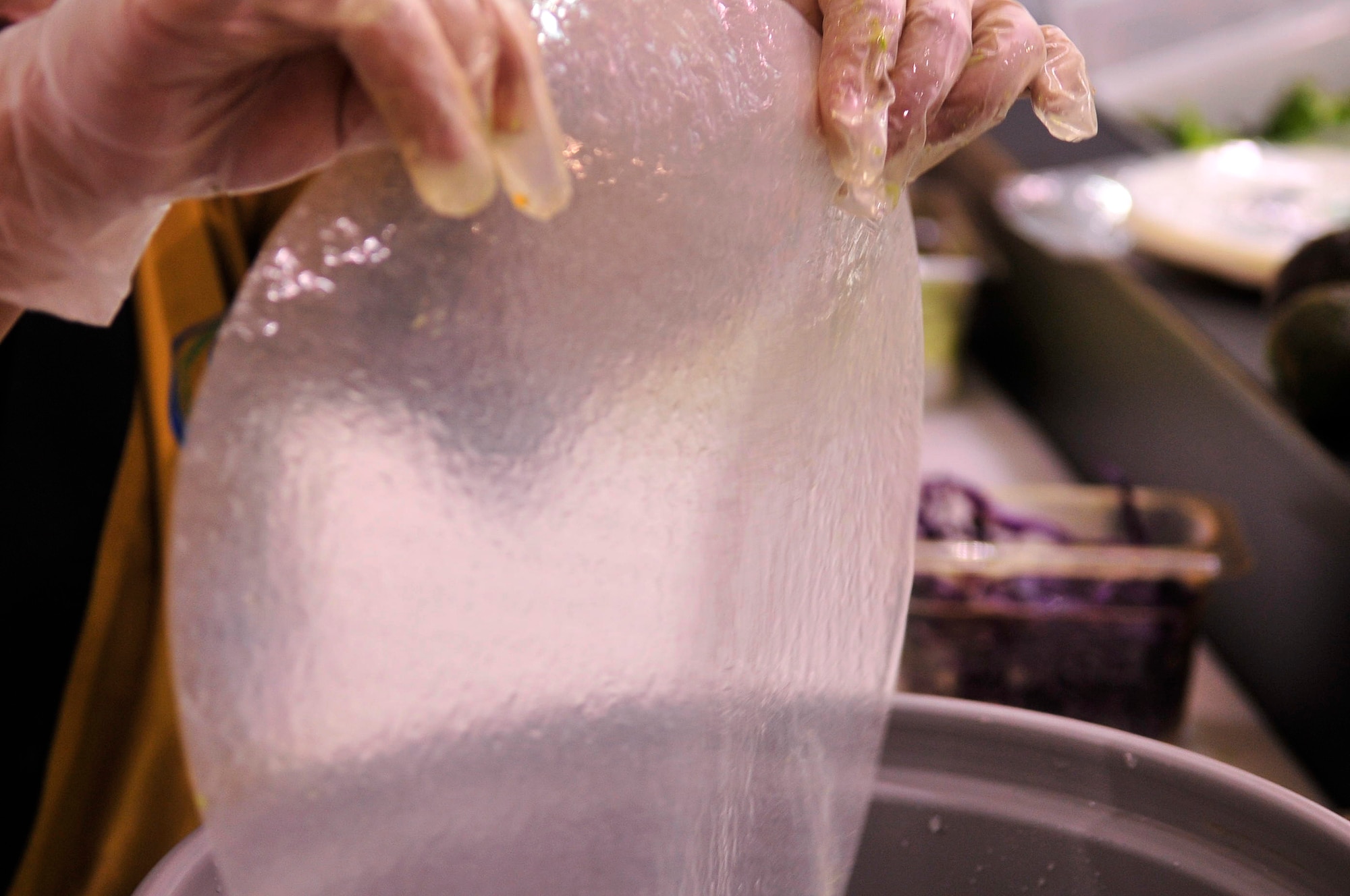 Buckley Air Force Base, Colo.-- Commissary sushi stand co-owner Naum Dim dips rice paper in water Jan. 13. Dipping the paper softens but strengthens it to make a better sushi roll. (U.S. Air Force photo by Airman 1st Class Manisha Vasquez)