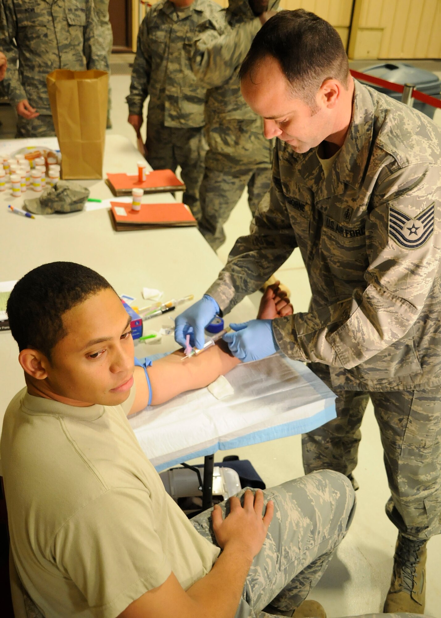 CANNON AIR FORCE BASE, N.M. --  Airman 1st Class David Showers, 27th Special Operations Support Squadron, gets blood drawn by Tech. Sgt. Michael Buongiorne, 27th Special Operations Medical Support Squadron, in preparation for deployment to Haiti. Approximately 45 Airmen from here prepared to support earthquake relief efforts in Haiti. (U.S. Air Force photo/Senior Airman Erik Cardenas) 